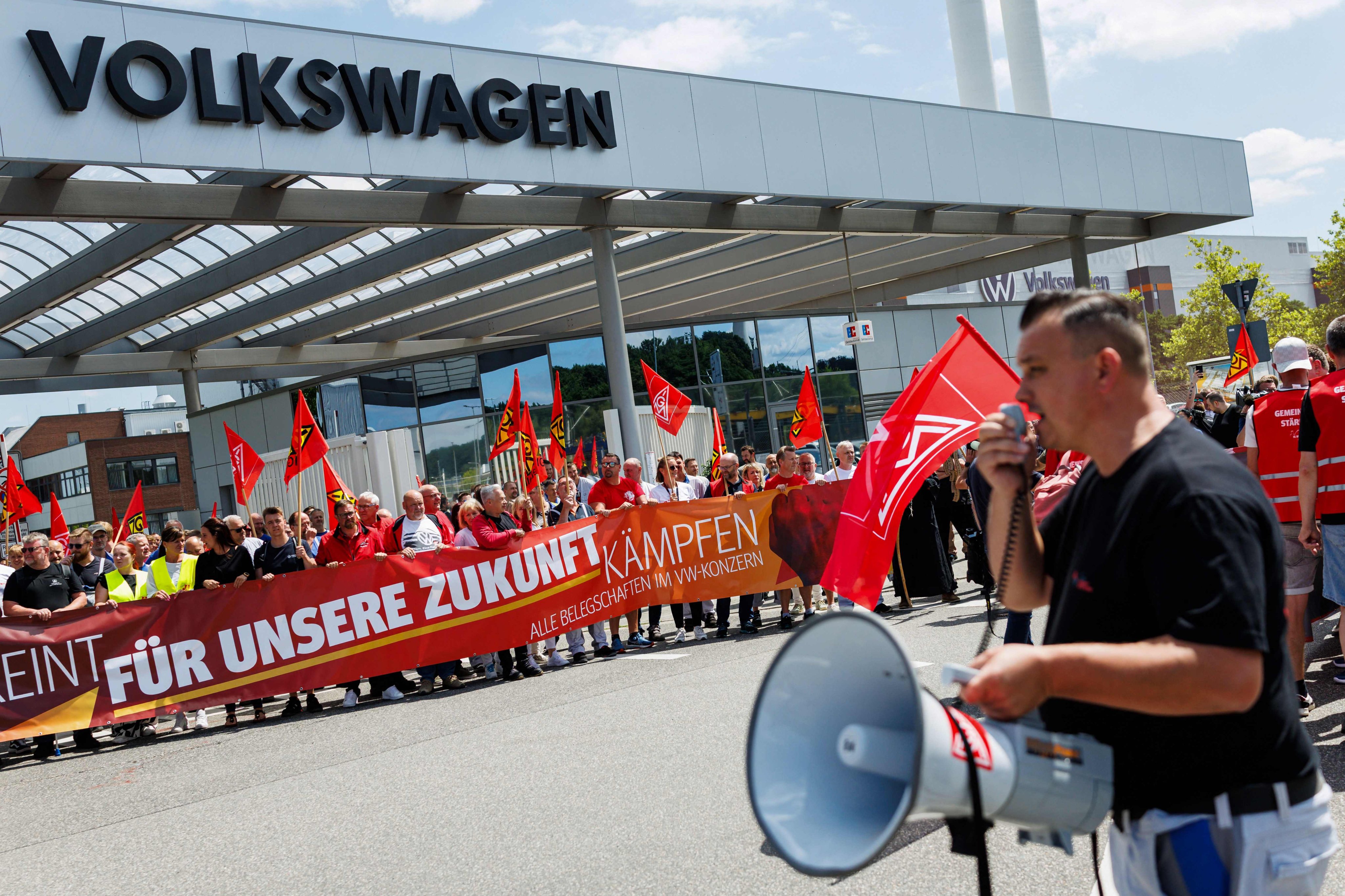 A participant addresses employees of German car maker Volkswagen during a rally by German trade union IG Metall to protest against restructuring and mass job cut plans, at the VW plant in Zwickau, eastern Germany, on July 9. Photo: AFP