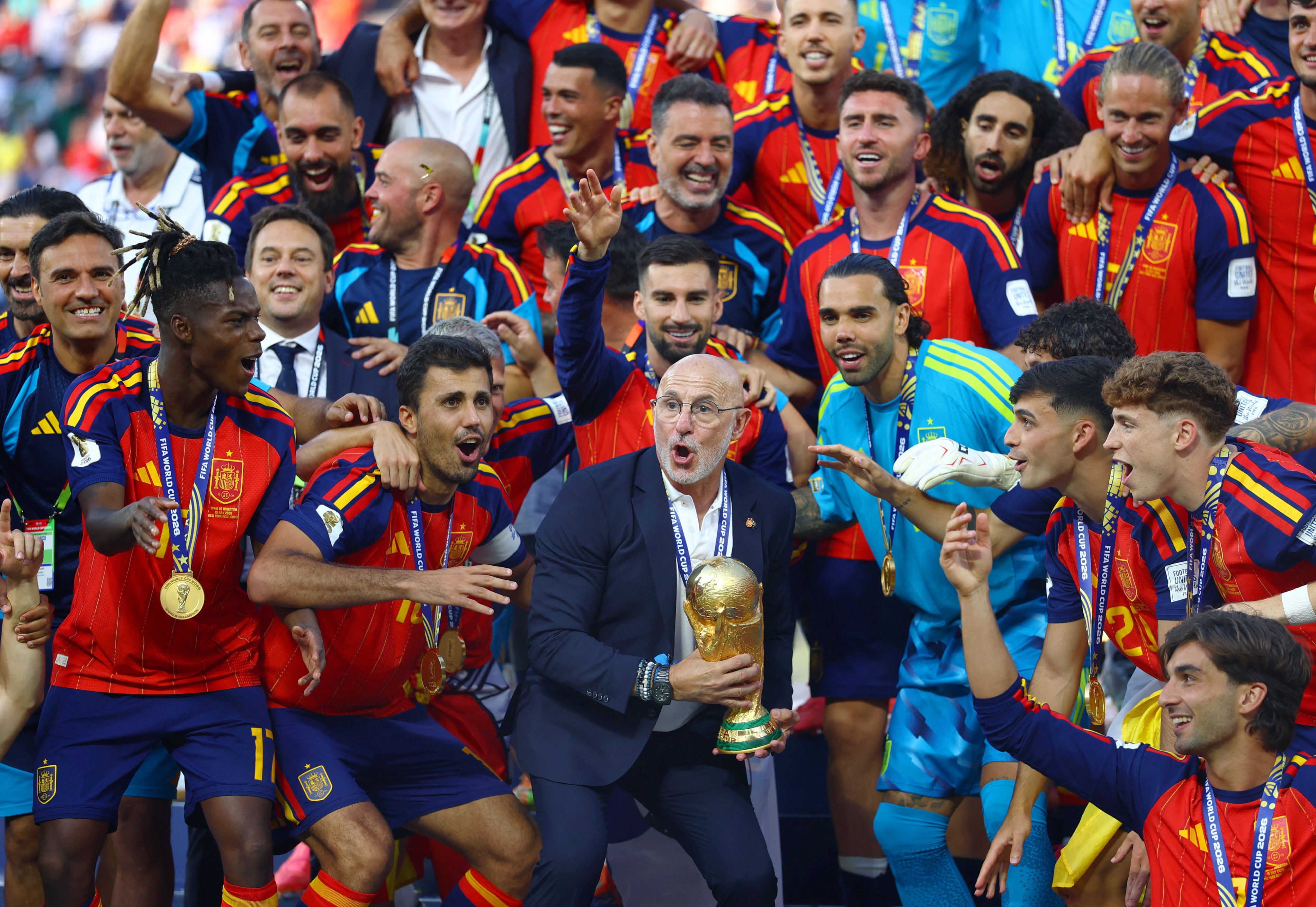 Spain coach Luis De La Fuente lifts the World Cup trophy alongside his players. Photo: Reuters