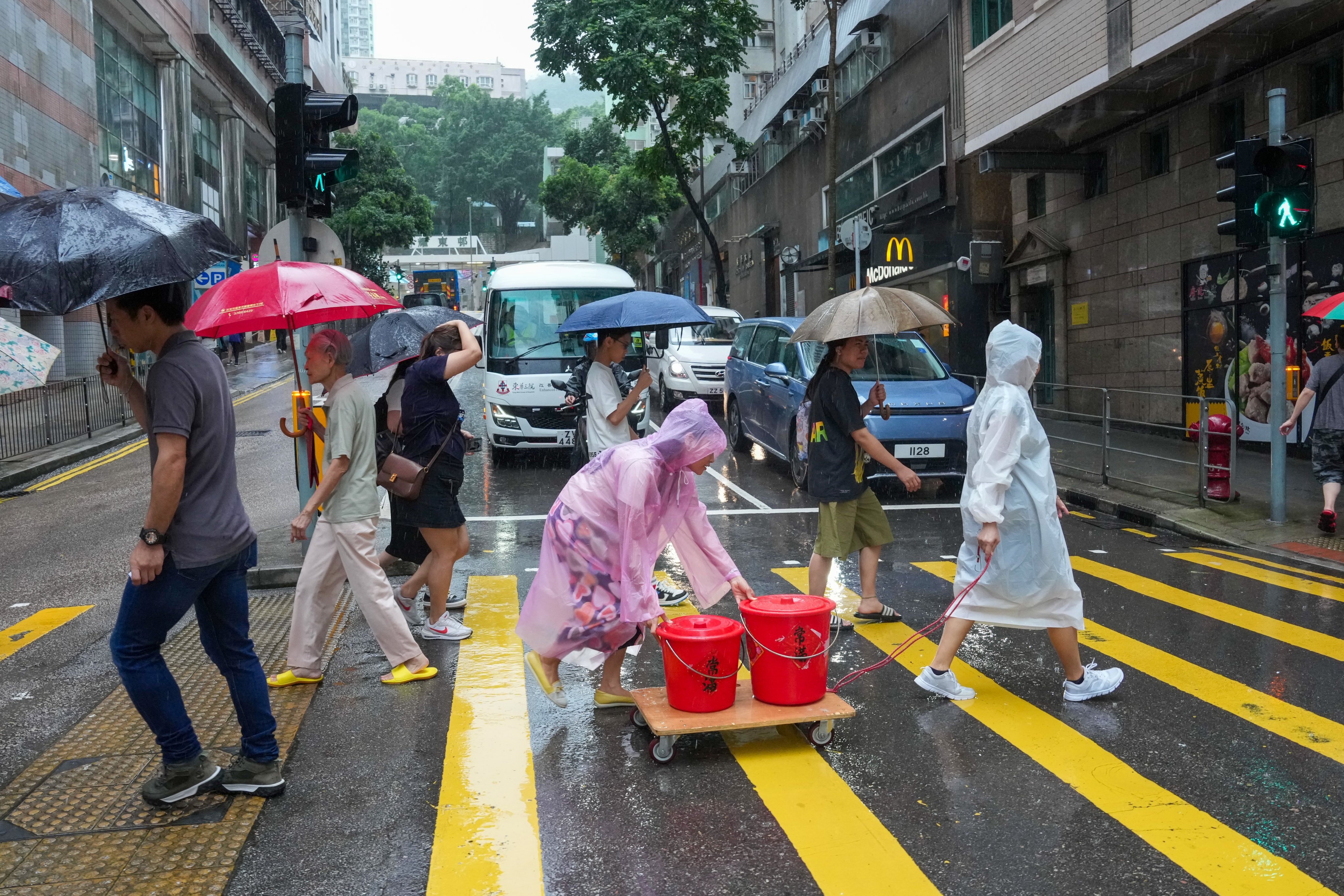 Residents brave heavy rain to collect water at a supply station in Shau Kei Wan after a burst underground pipe affects over 10,000 households in the area. Photo: Jelly Tse