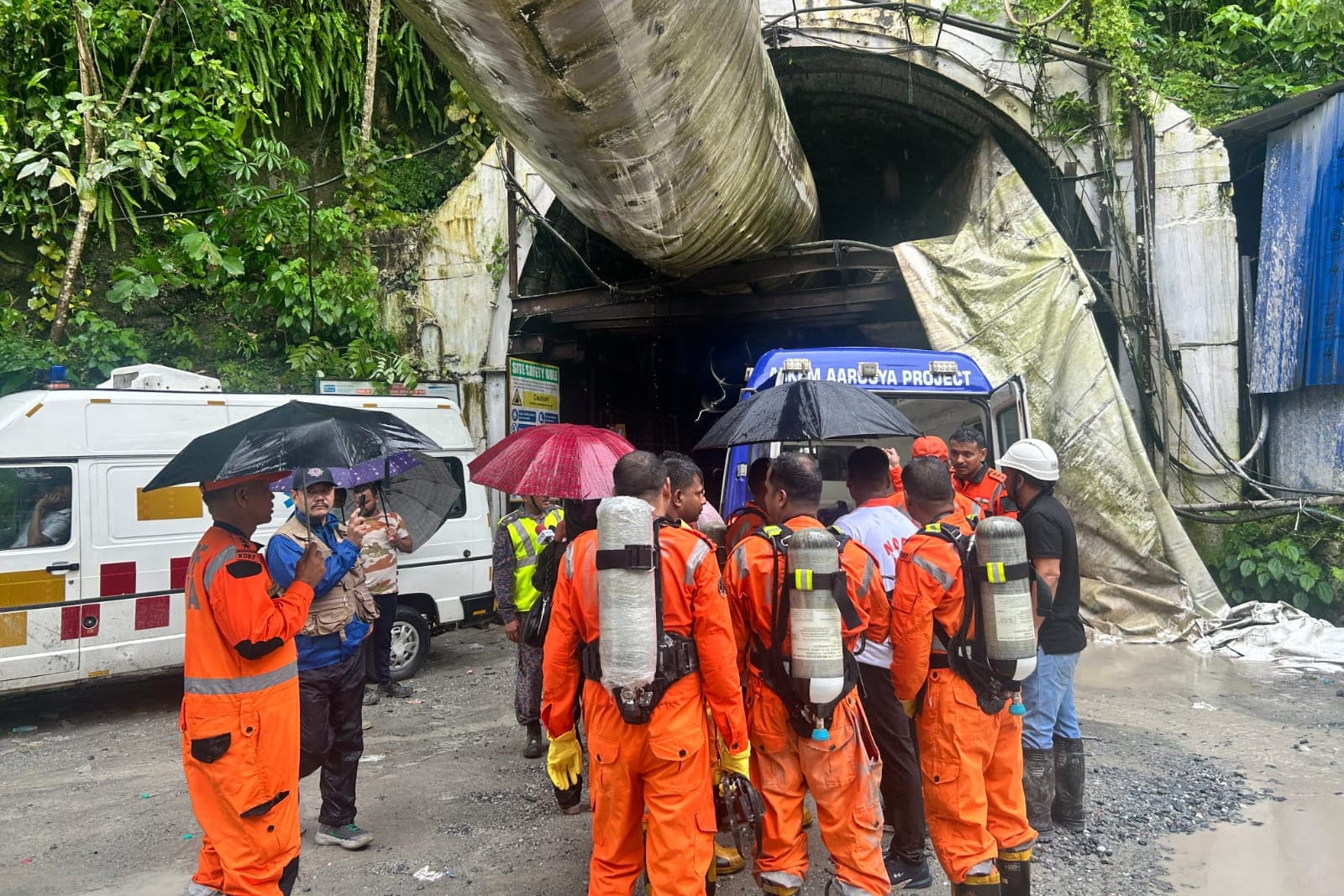 Members of the rescue team carry oxygen cylinders outside the entrance to an under-construction tunnel at a hydropower project in Samardung village, about 40km (25 miles) from Gangtok, India, on Tuesday. Photo: AP