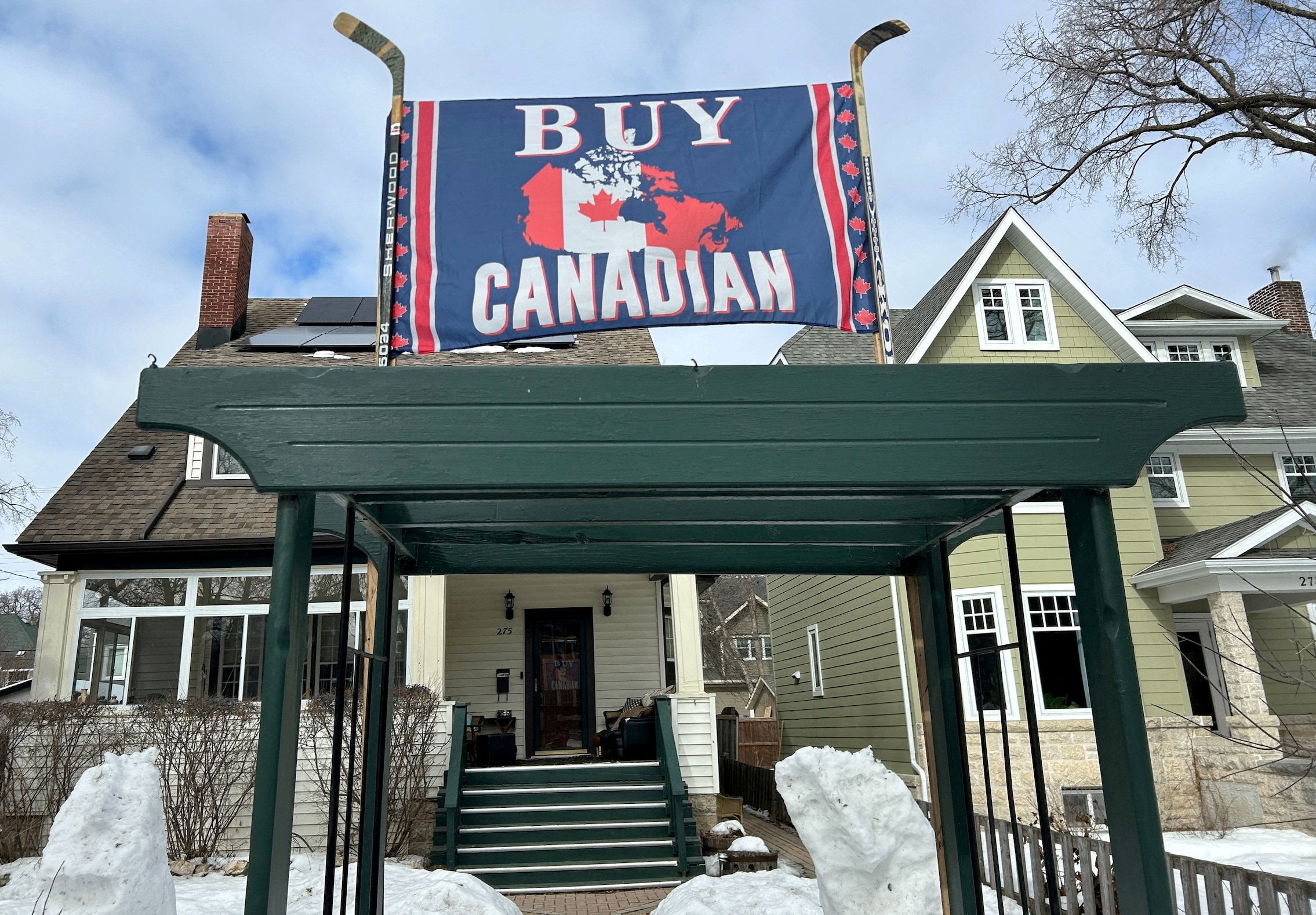 A banner reading “Buy Canadian”, in response to US President Donald Trump’s tariffs on goods from Canada, is held aloft by a pair of hockey sticks in front of a house in Winnipeg, Manitoba, in March 2025. Photo: Reuters