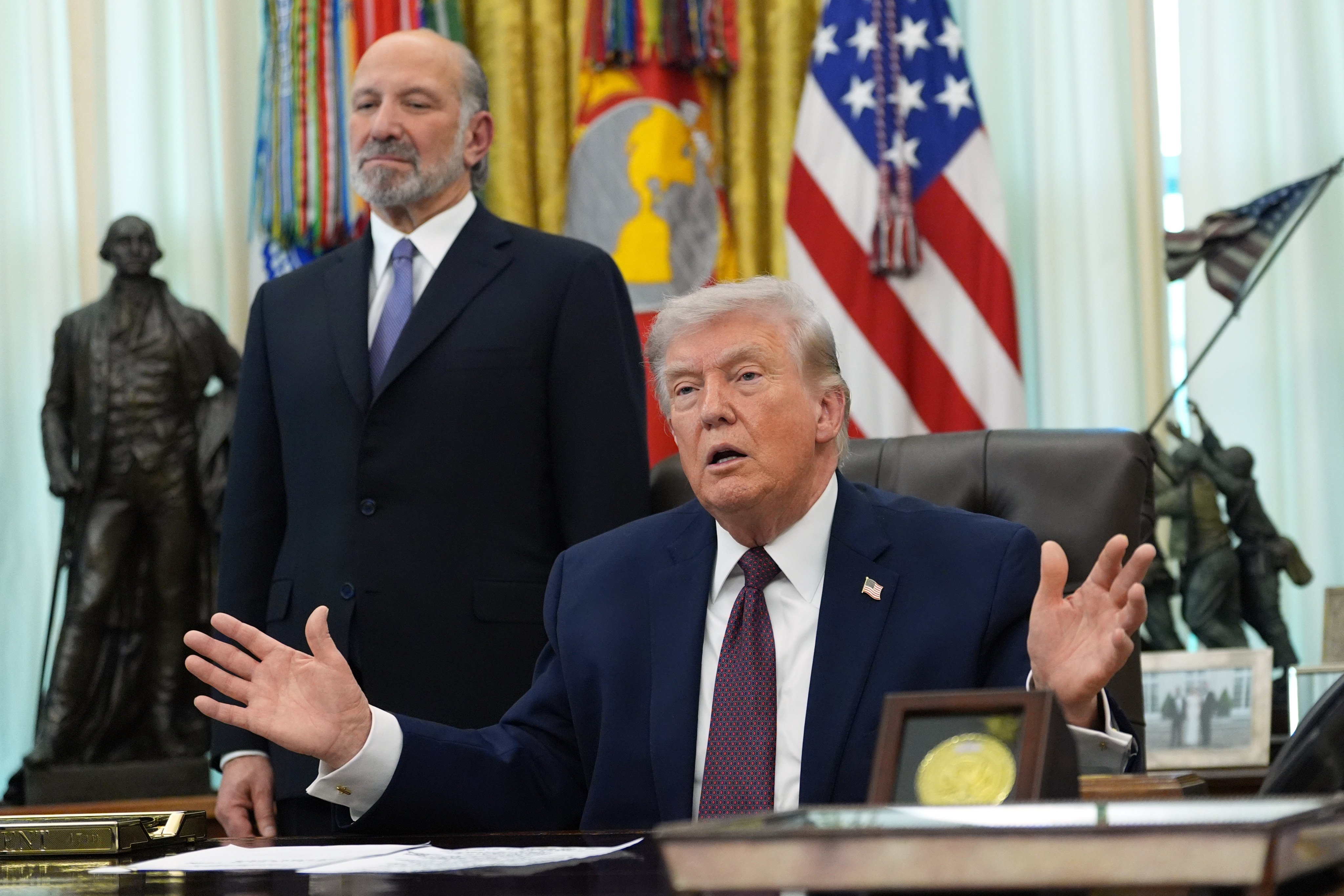 US President Donald Trump answers questions from reporters after signing an executive order in the Oval Office of the White House on March 31, in Washington, as Commerce Secretary Howard Lutnick listens. Photo: AP