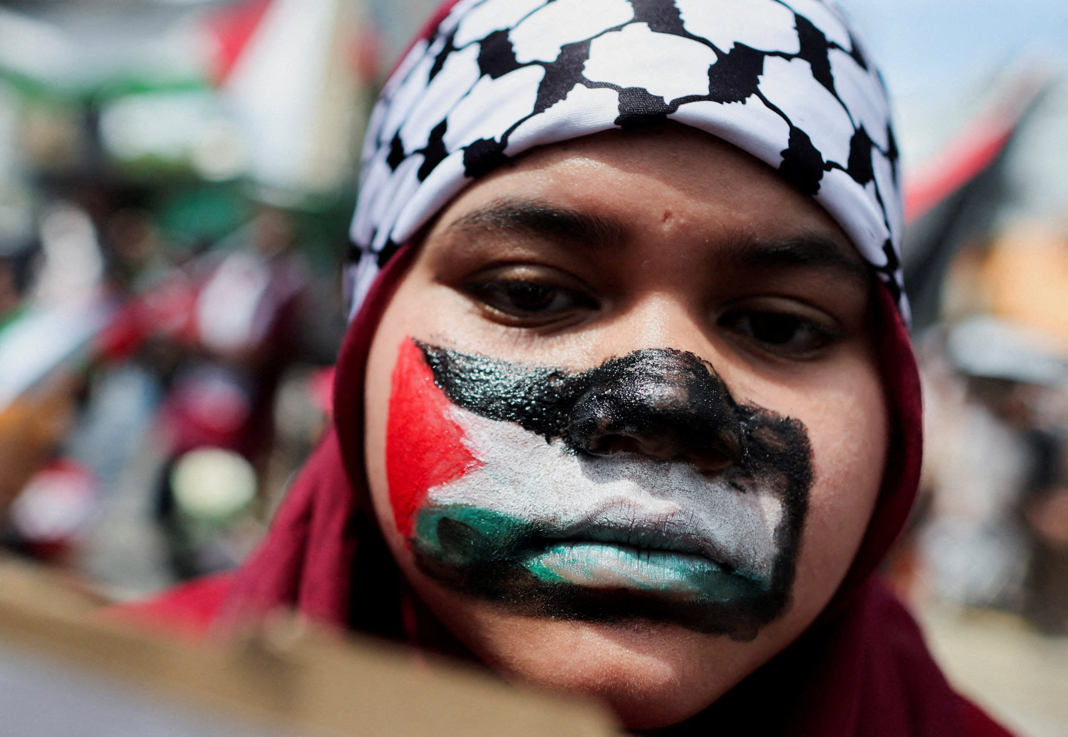 A pro-Palestinian supporter paints her face with the Palestinian flag during a march to the US Embassy in Kuala Lumpur on March 13. Photo: Reuters
