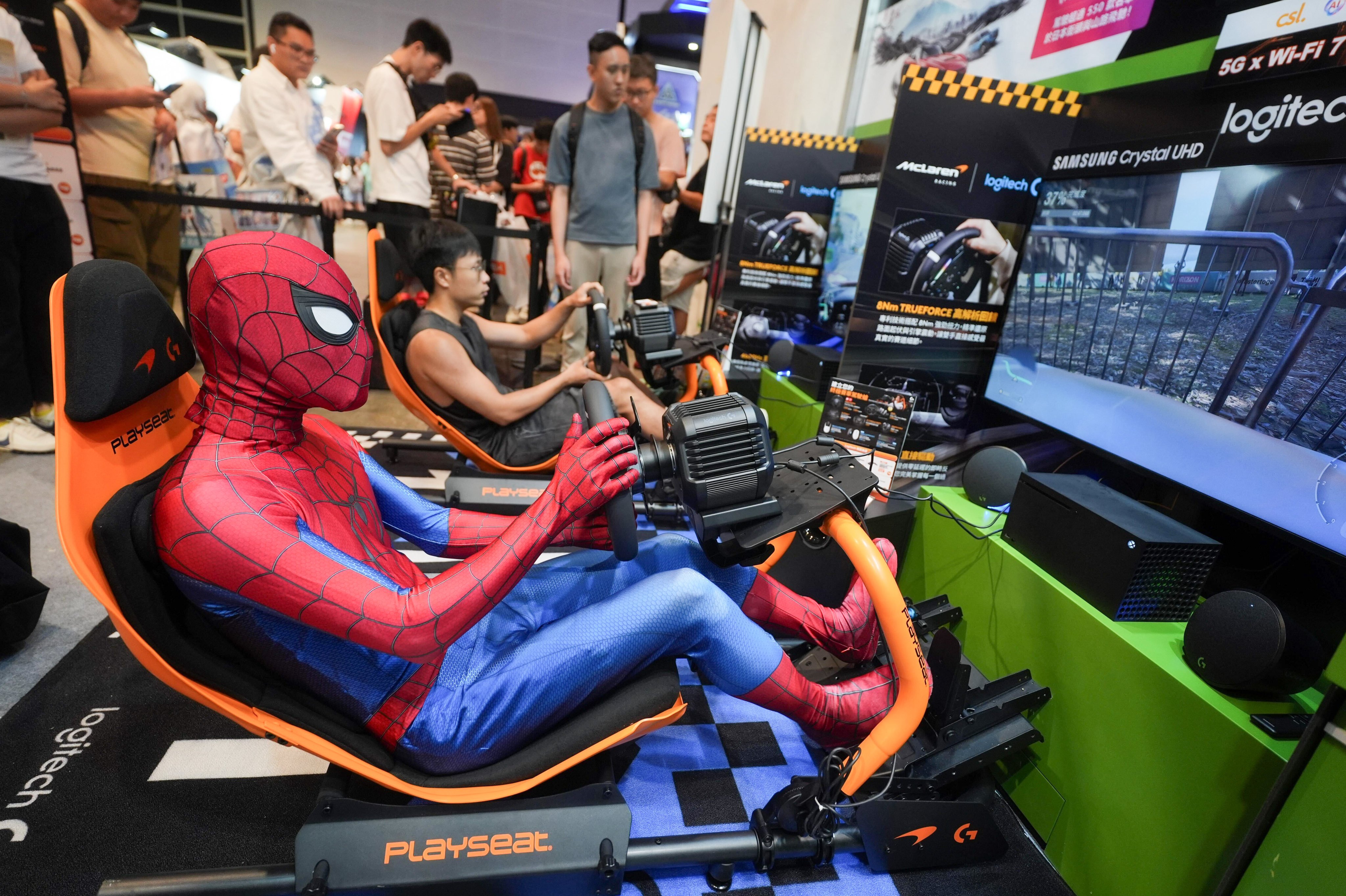 A visitor in a Spider-Man costume tries his hand at a video game. Photo: Elson Li