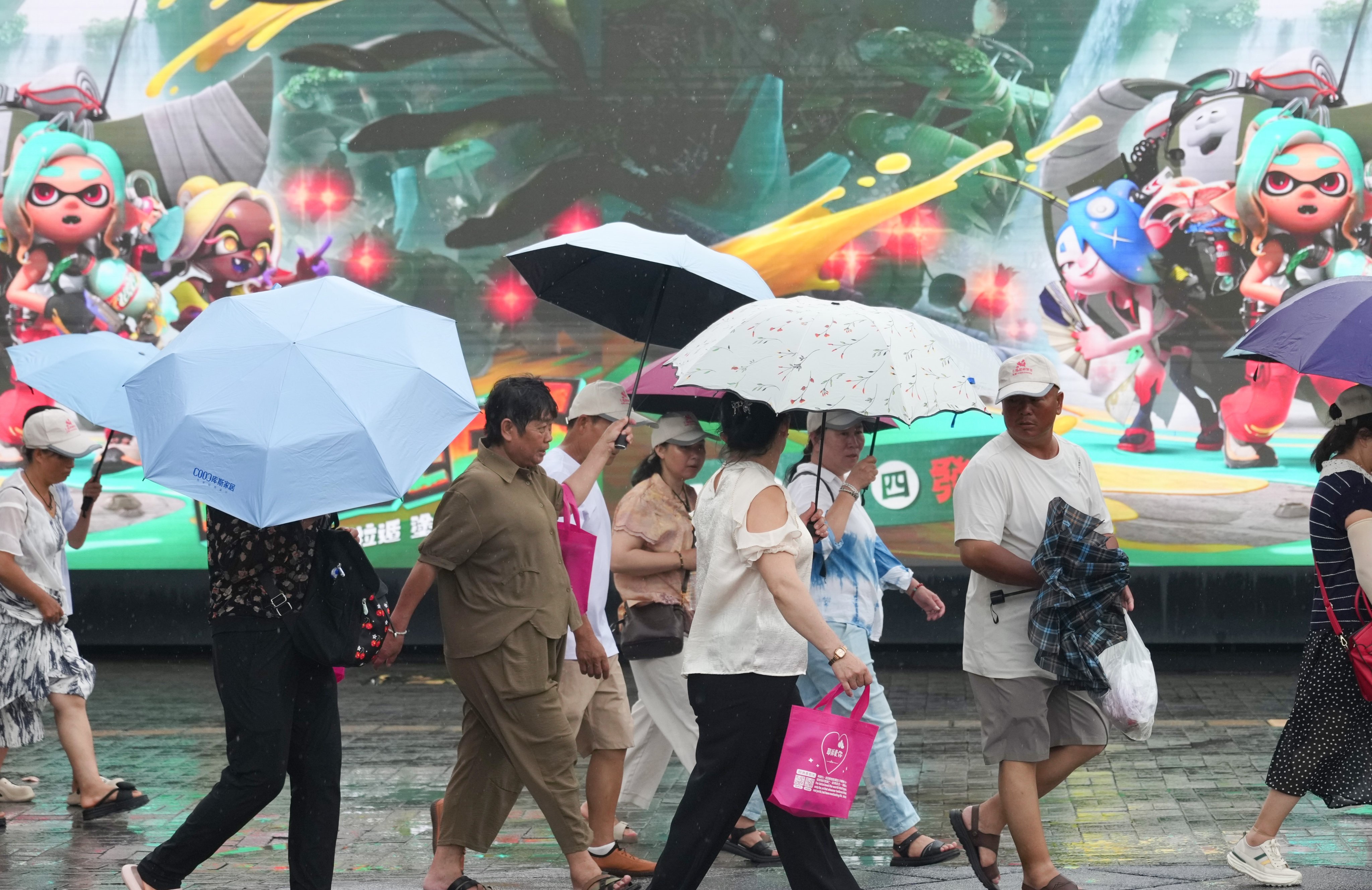 Pedestrians shield themselves with umbrellas during a sudden downpour in Tsim Sha Tsui on Saturday. Photo: Karma Lo