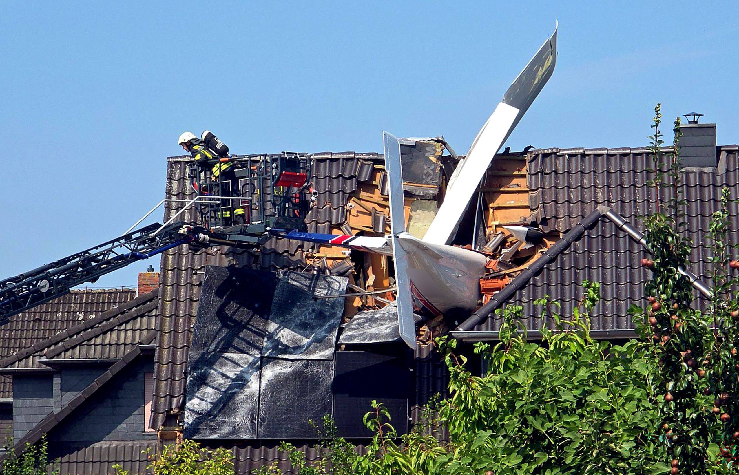 A small plane that crashed is lodged in the roof of a house in Ganderkesee, Germany. Photo: dpa