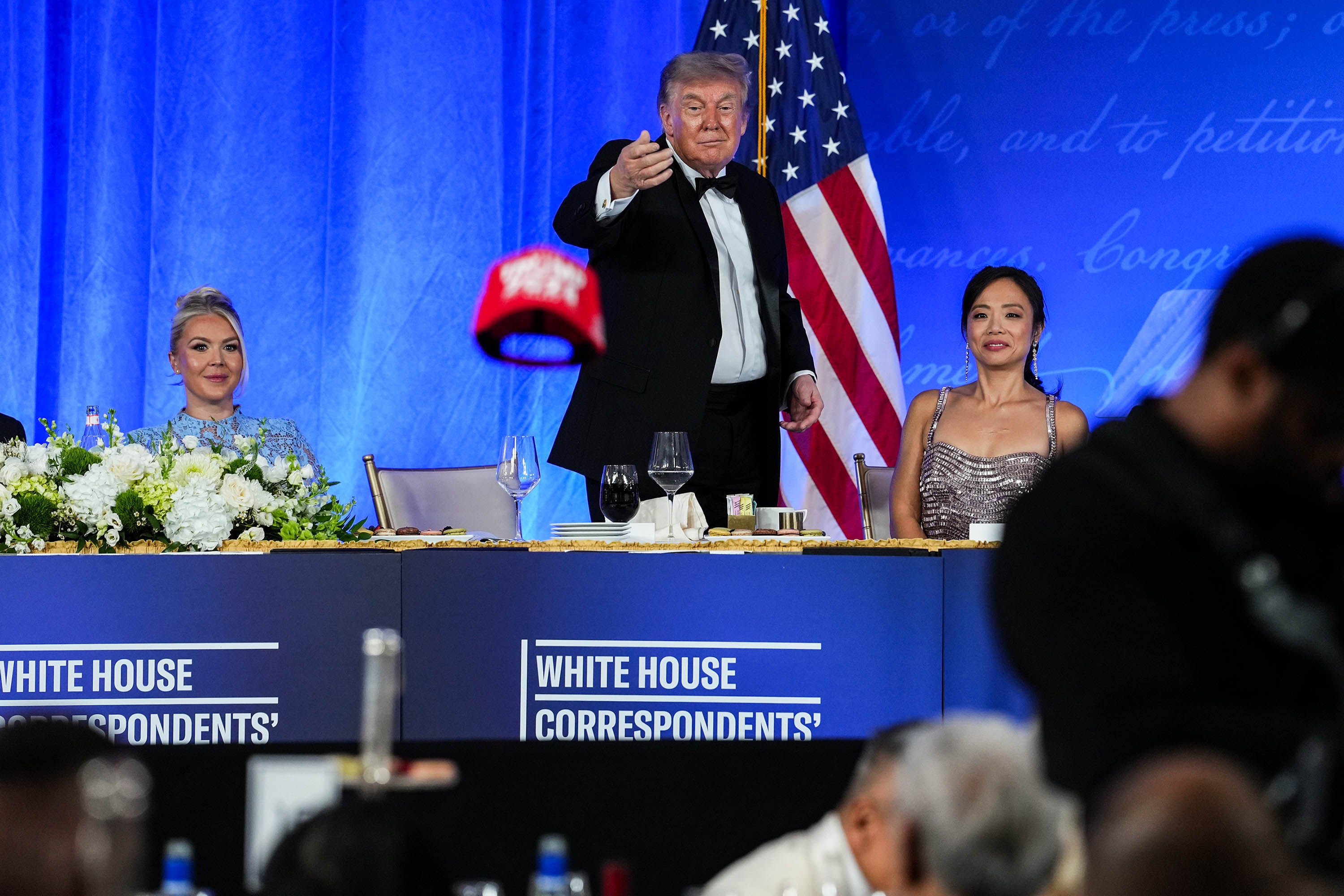 US President Donald Trump tosses his Trump 2028 hat to an attendee during the  White House Correspondents Dinner on Friday. Photo: Getty Images/TNS