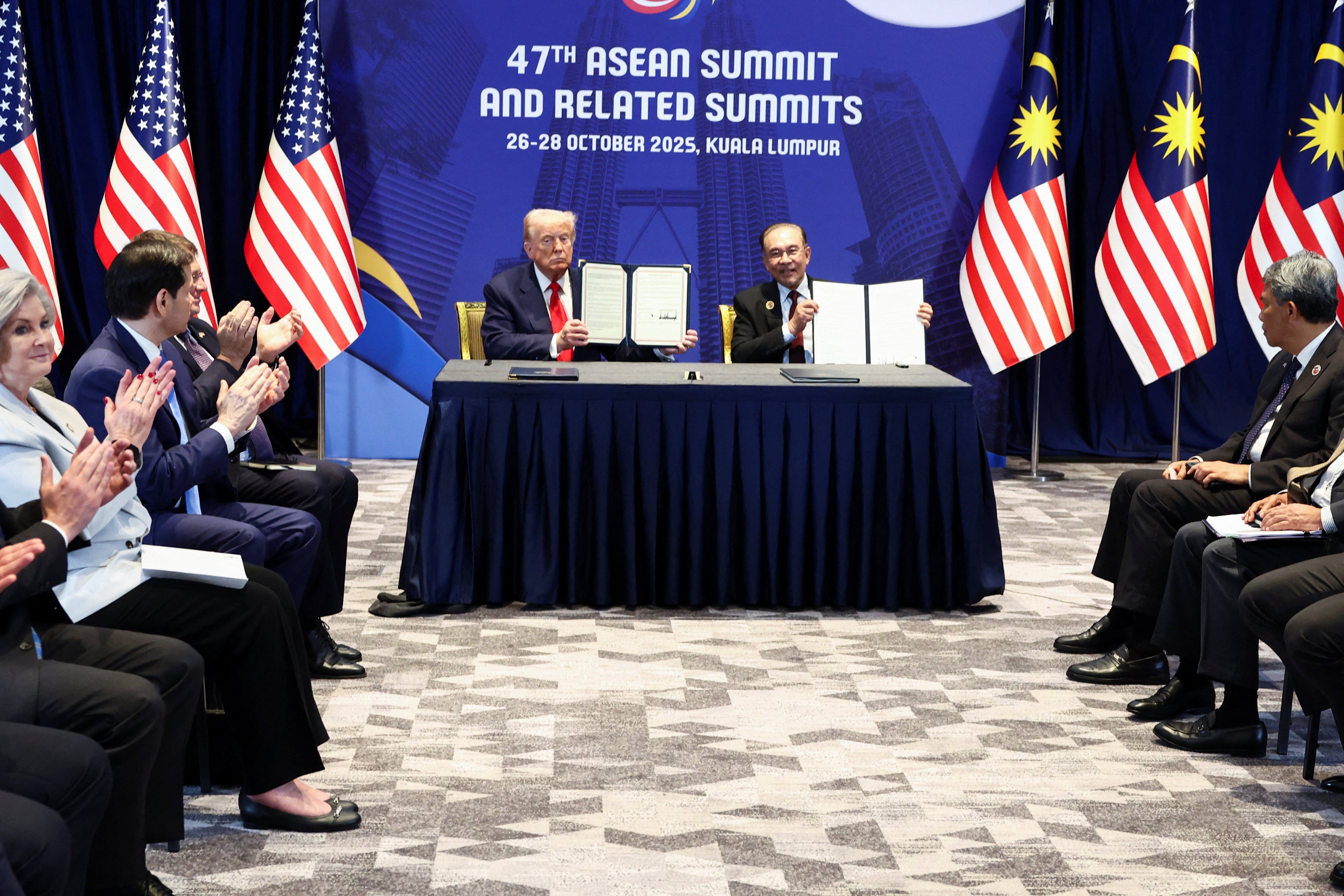 US President Donald Trump and Malaysian Prime Minister Anwar Ibrahim hold up trade deal documents during a meeting in Kuala Lumpur in October. Photo: Reuters