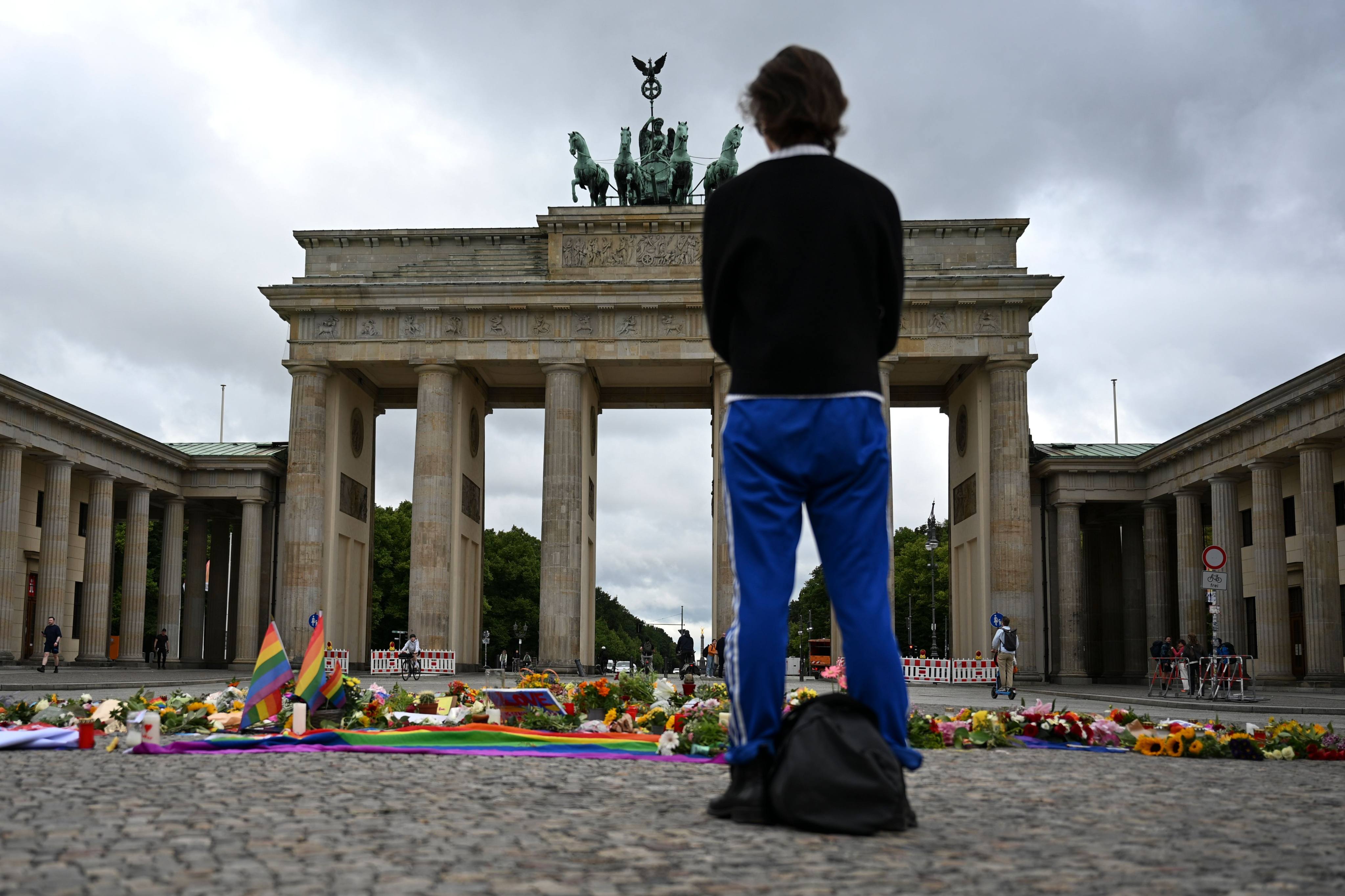 A person stands in front of the Brandenburg Gate, where flowers, candles, and personal messages have been left following the attack on Saturday. Photo: dpa