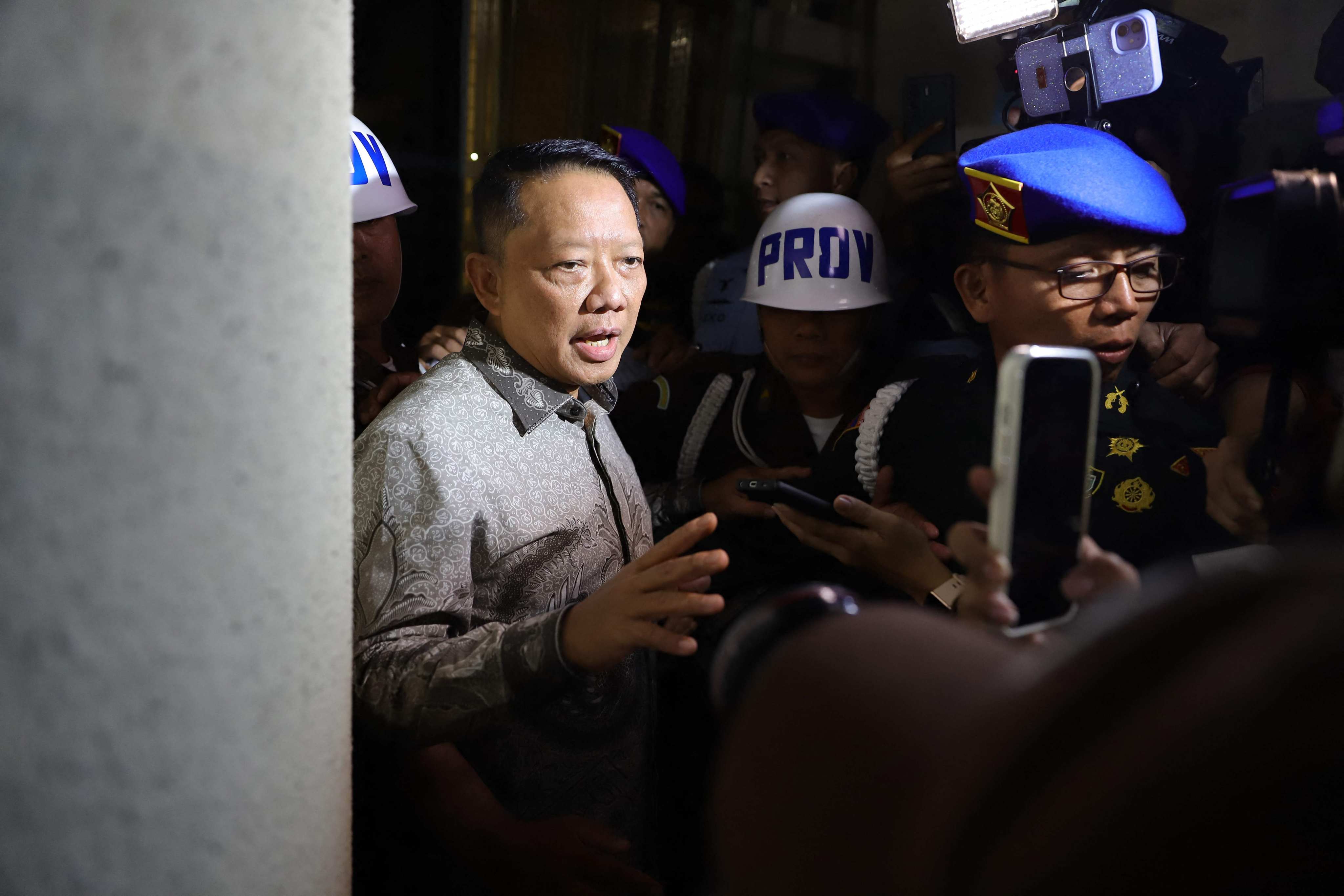 Febrie Adriansyah (left) is escorted to a police vehicle after being questioned at the main building of the Attorney General’s Office in Jakarta, Indonesia, on Friday. Photo: AFP
