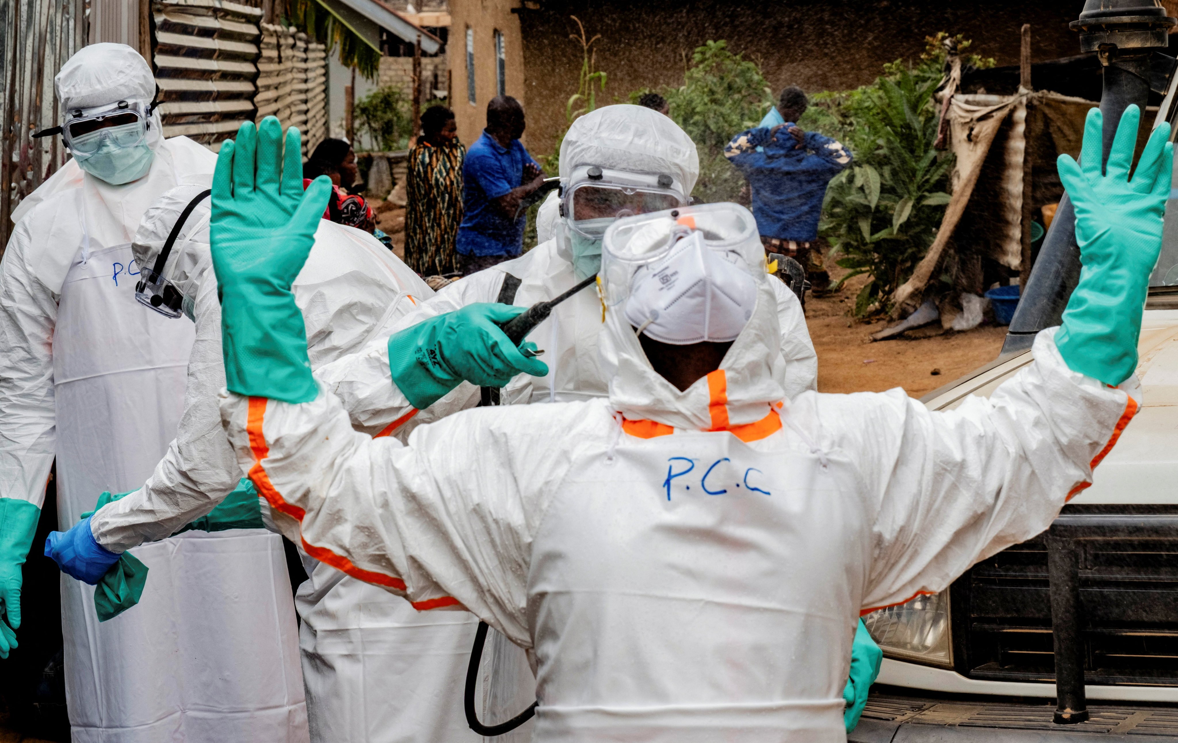 Members of the Civil Protection, a local community-based team that works to help mitigate the spread of the Ebola virus, disinfect after handling the body of an unidentified man, who according to his family, died of Ebola after retrieving it from his house, in Bunia, Ituri province, Democratic Republic of Congo, on July 10. Photo: Reuters