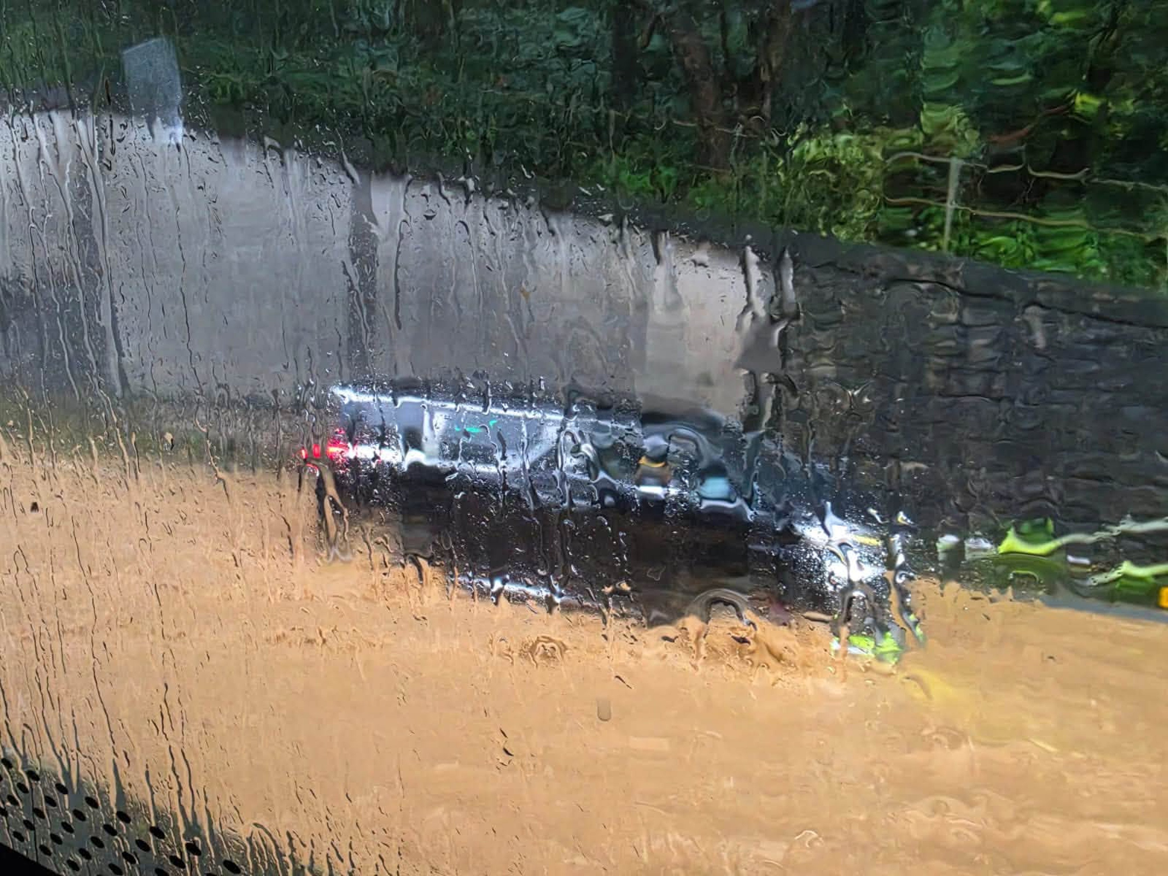 A car travels on a flooded section of the road from Tai Wo to Sheung Shui. Photo: Handout
