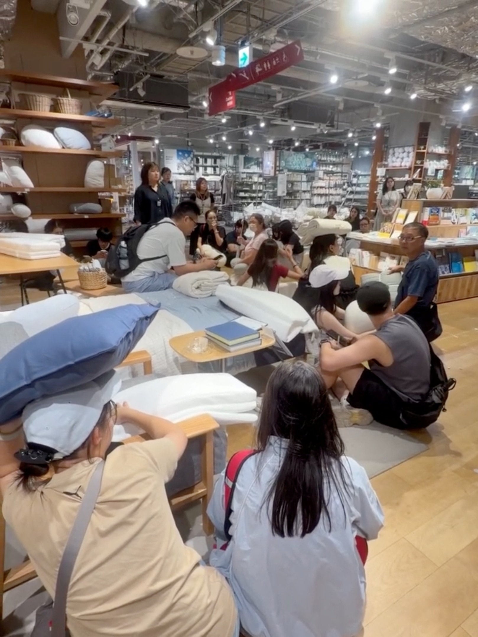 People take cover in a Muji store as an earthquake strikes Kumamoto city on Tuesday. Photo: Handout/Reuters