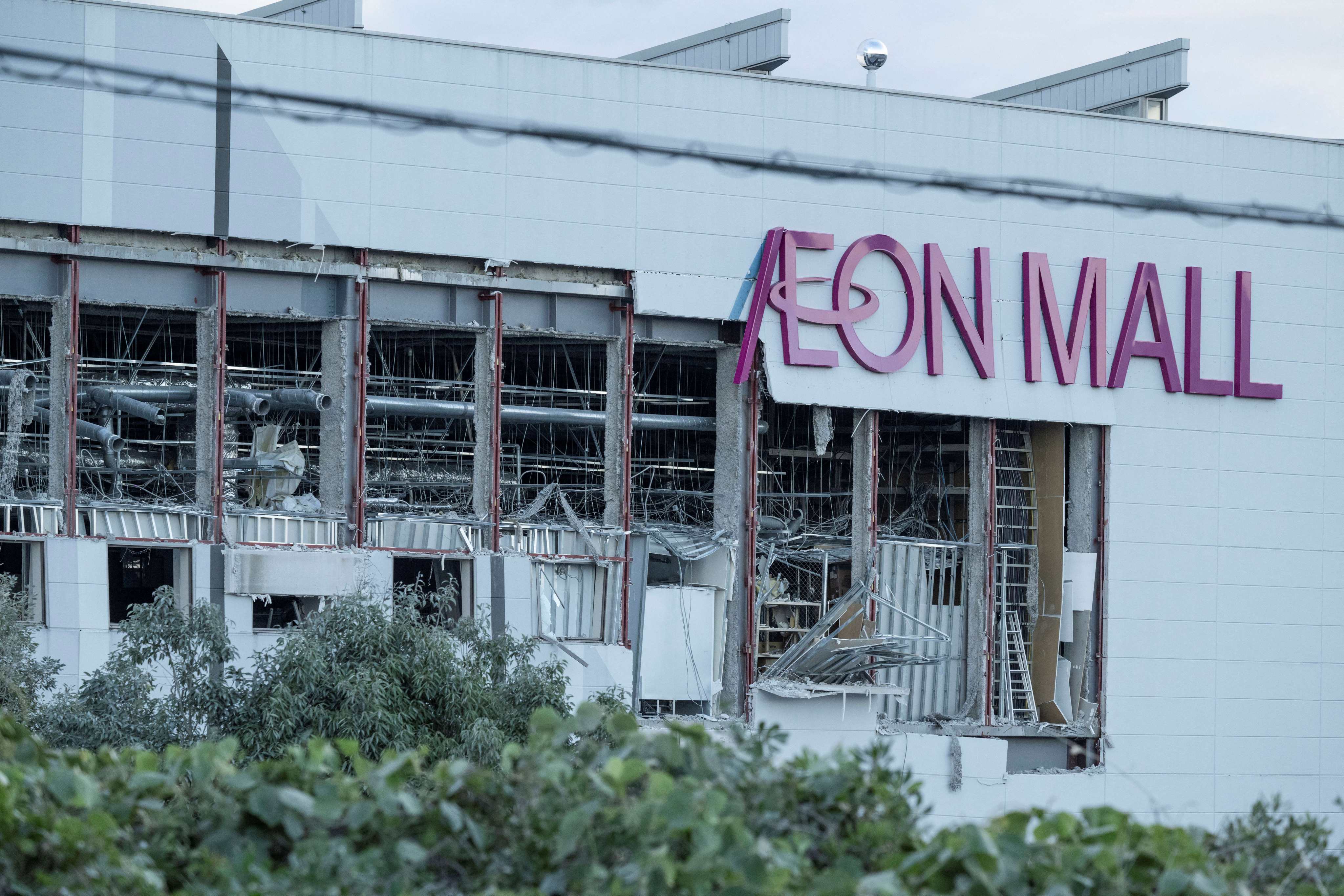 Damage is seen to part of the Aeon Mall Kumamoto in Kashima, Kumamoto Prefecture, on July 29, 2026 after an earthquake struck the area. Two young women were found dead early Wednesday in a mall badly damaged by a powerful earthquake and subsequent explosion, local media reported early Wednesday, as crews continued searching overnight for missing people. (Photo by Yuichi YAMAZAKI / AFP)