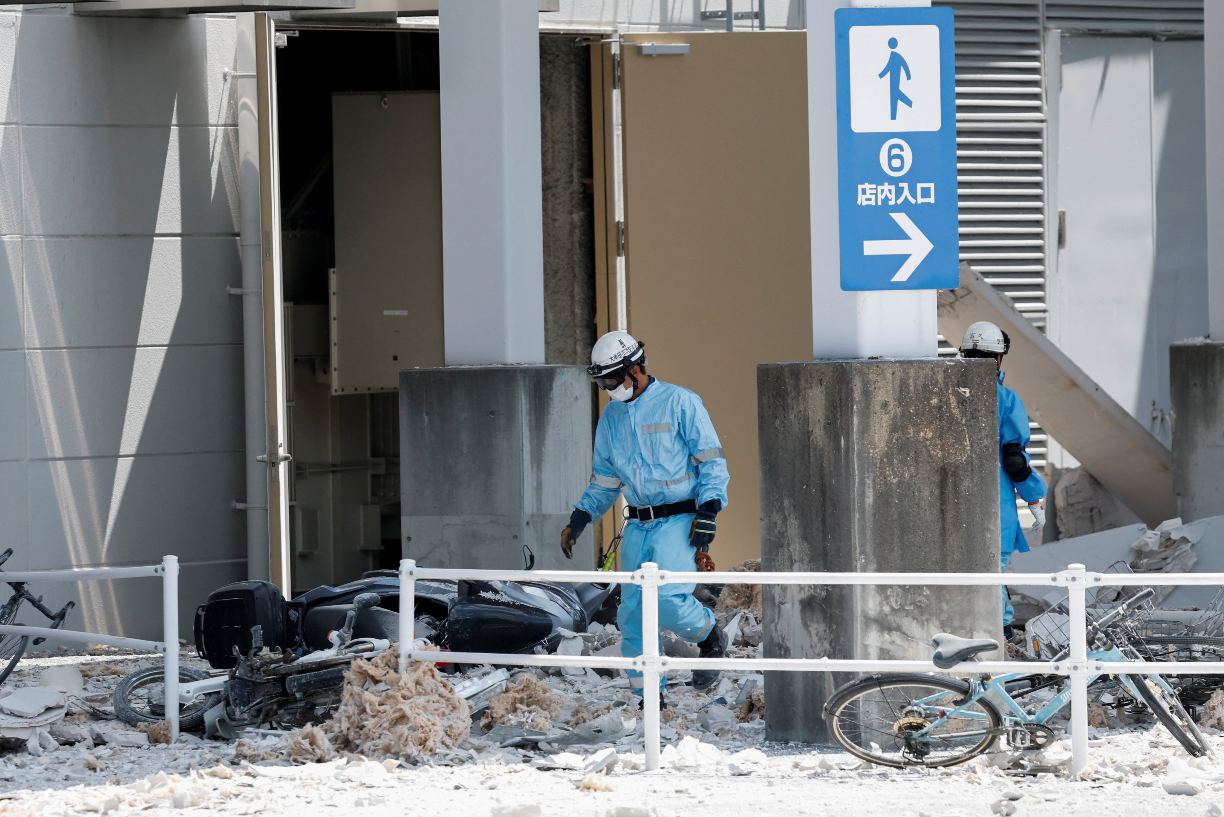 Emergency workers walk through the rubble of the damaged Aeon Mall on Wednesday. Photo: Reuters