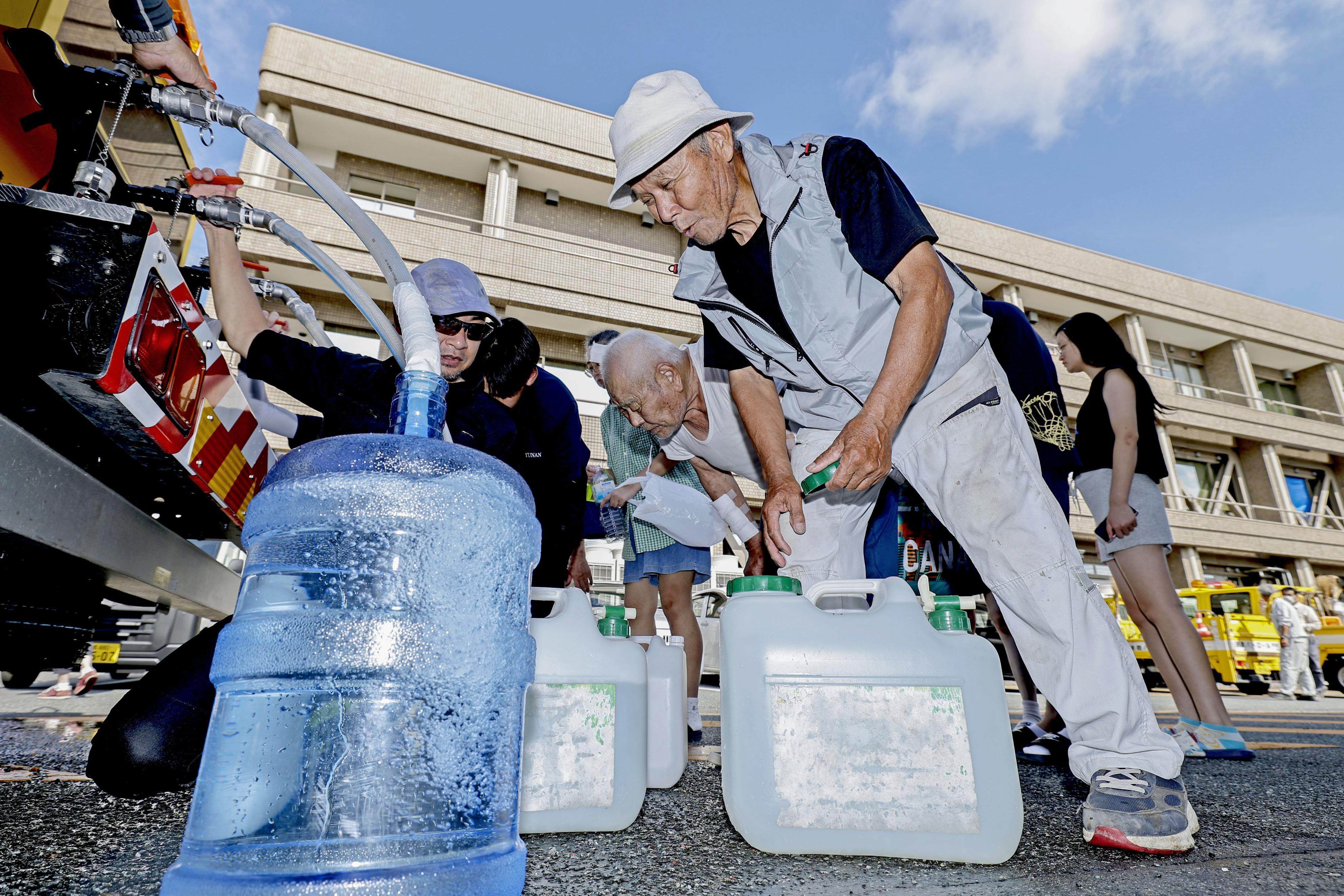 People collect water in quake-hit Uki, Kumamoto prefecture, on Thursday. Photo: Kyodo