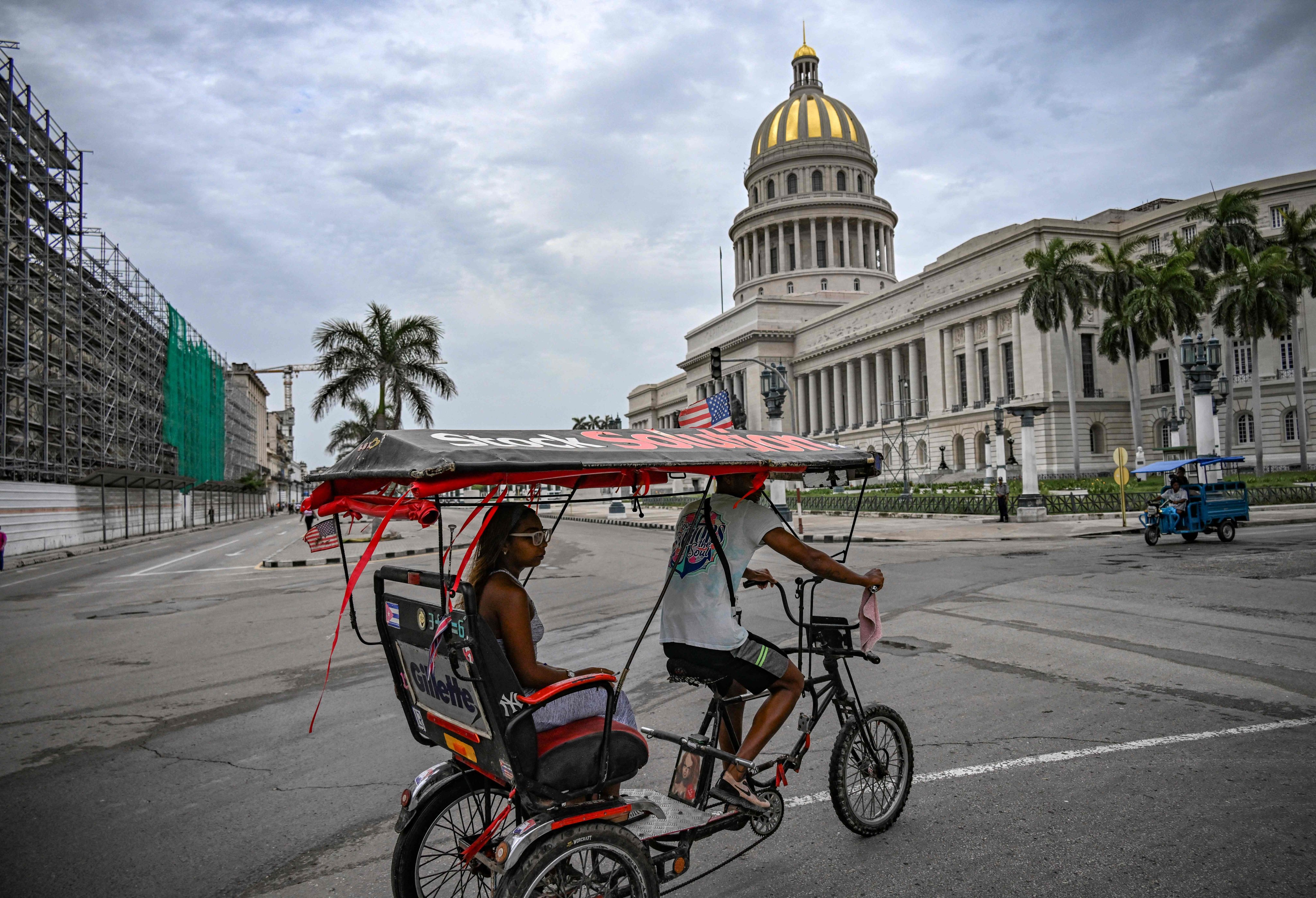 A bicycle taxi decorated with a US flag passes in front of the Havana Capitol. Photo: AFP