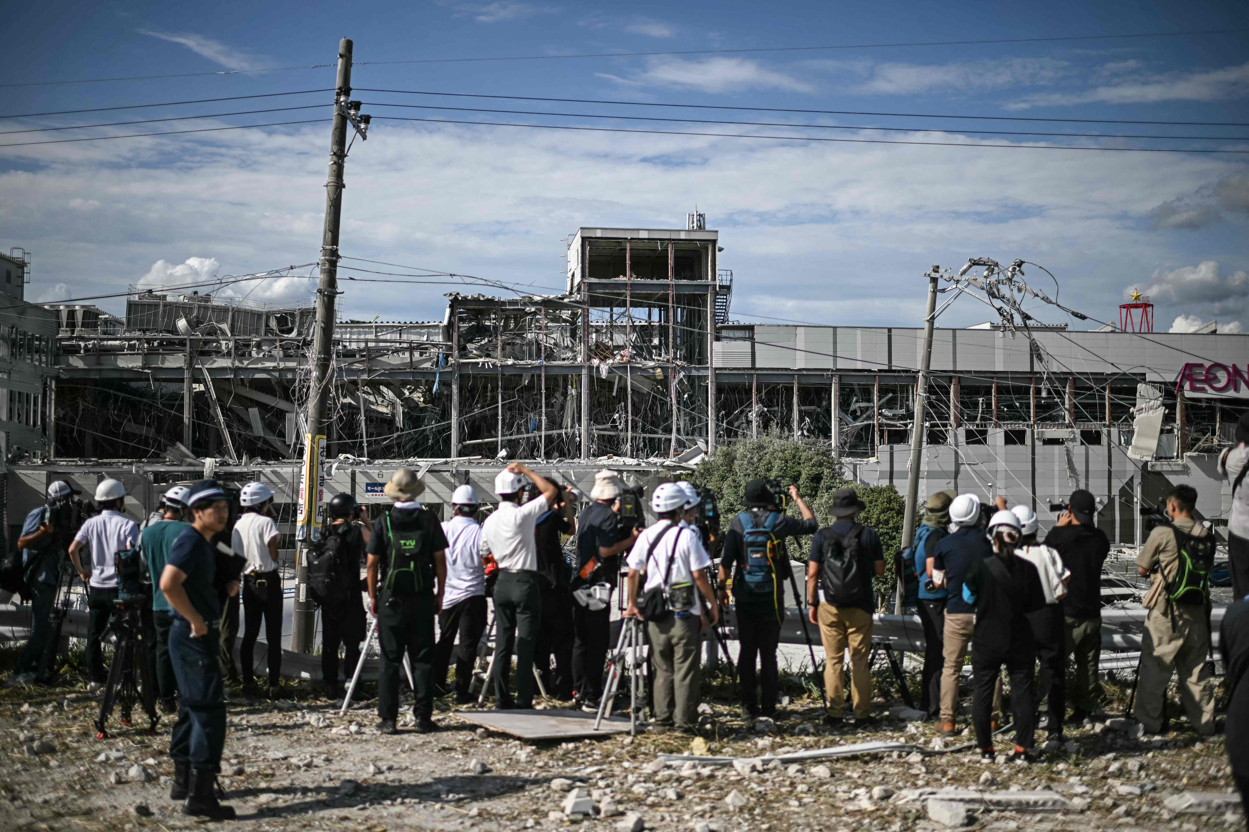 Journalists gather outside the damaged Aeon mall in Kashima, Kumamoto, on Wednesday after an earthquake struck southwestern Japan the previous day. Photo: AFP