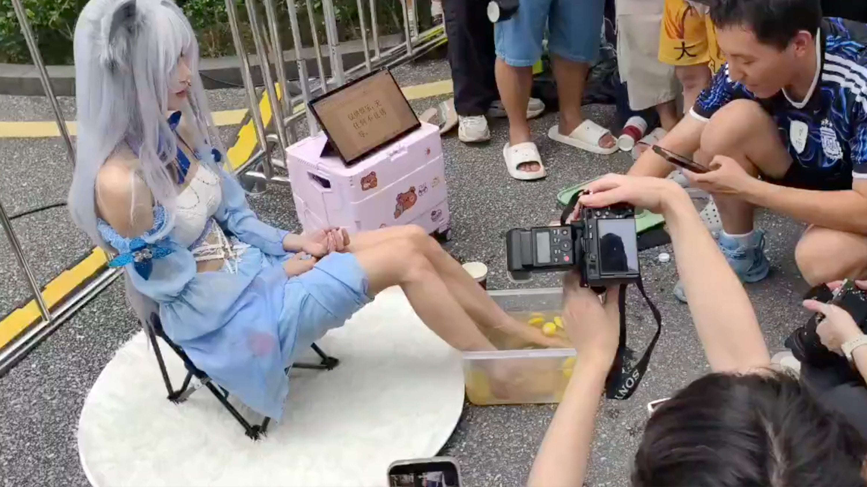 At an anime convention in Guangzhou, a cosplayer drew crowds and criticism by selling "feet juice" — a concoction of lemon-infused water from large tubs where she soaked her feet, priced at 50 yuan (US$7) per cup. Photo: Bilibili