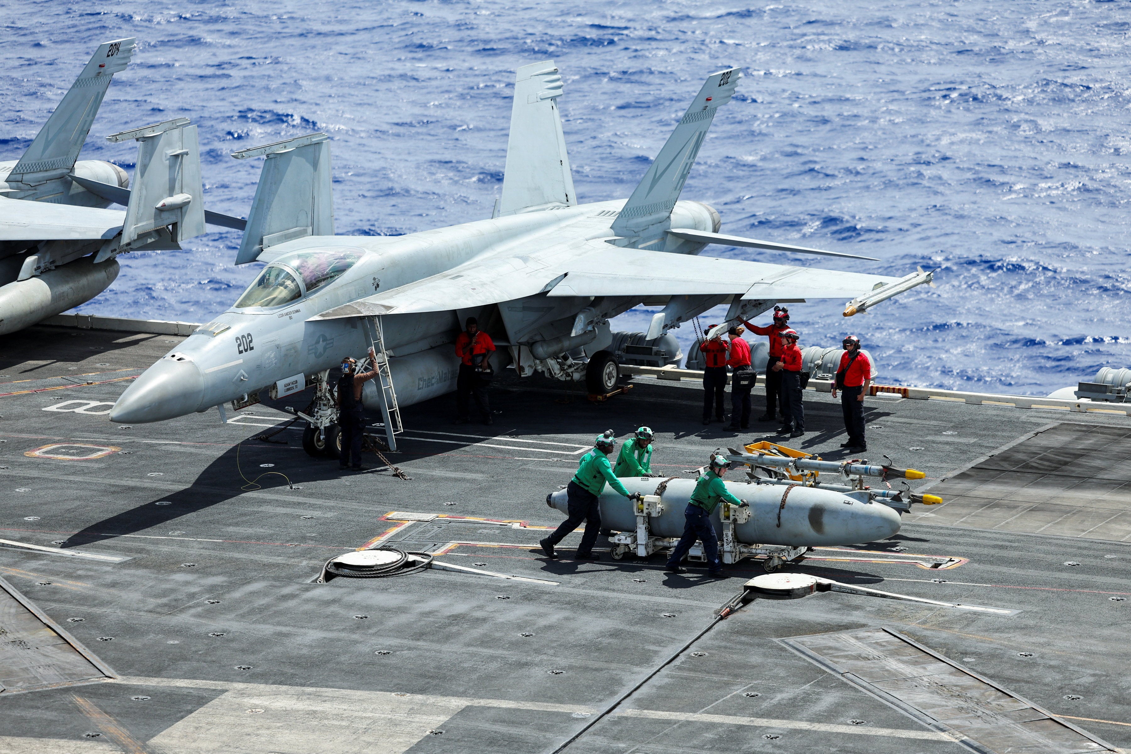 Flight deck crew move a fuel tank onboard the USS Theodore Roosevelt as the aircraft carrier participates in the Rimpac exercise in waters south of the Hawaiian Islands on July 13. Photo: Reuters