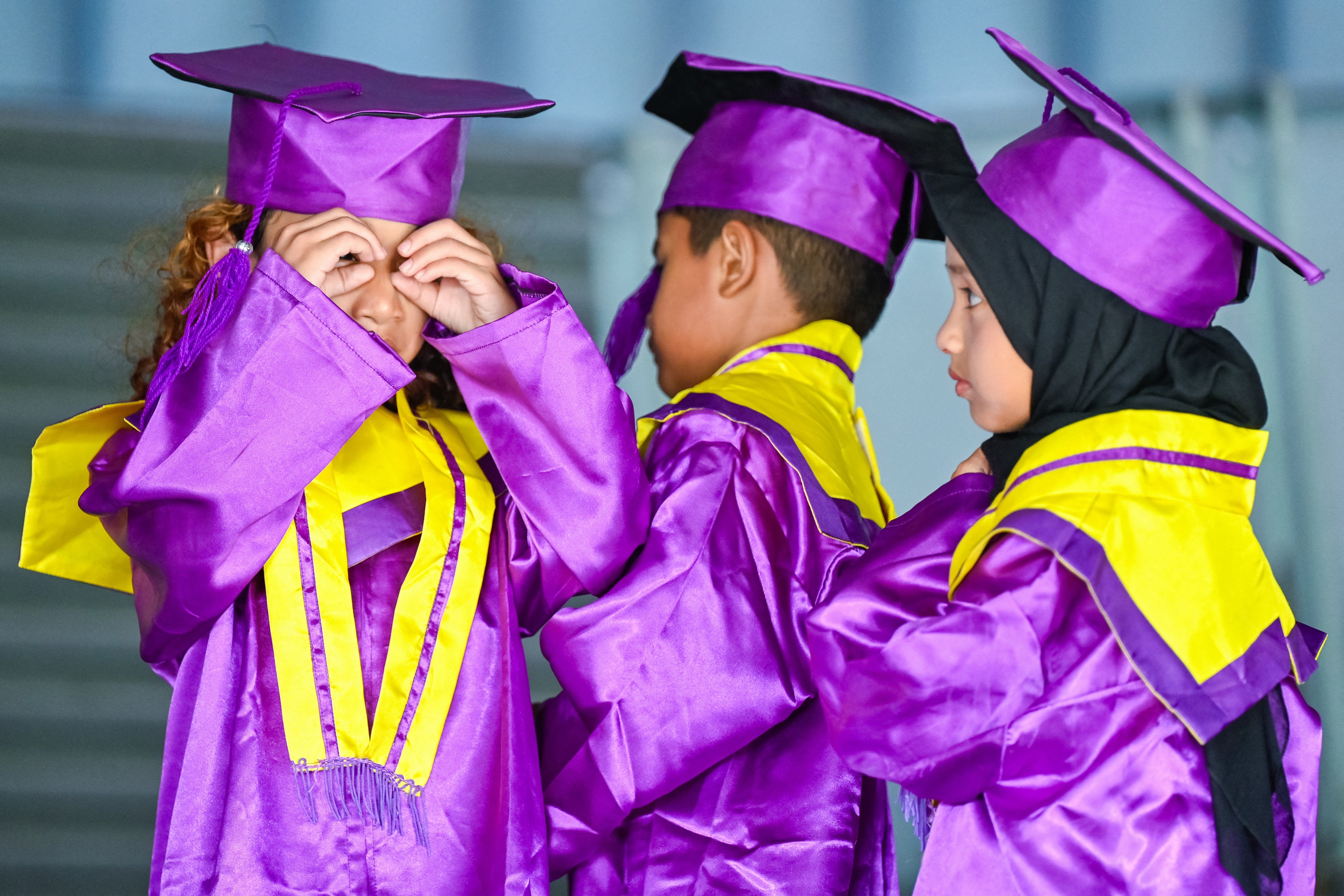 Kindergarteners wearing graduation gowns wait to have their photographs taken at a museum in Banda Aceh, Indonesia, in May. Photo: AFP