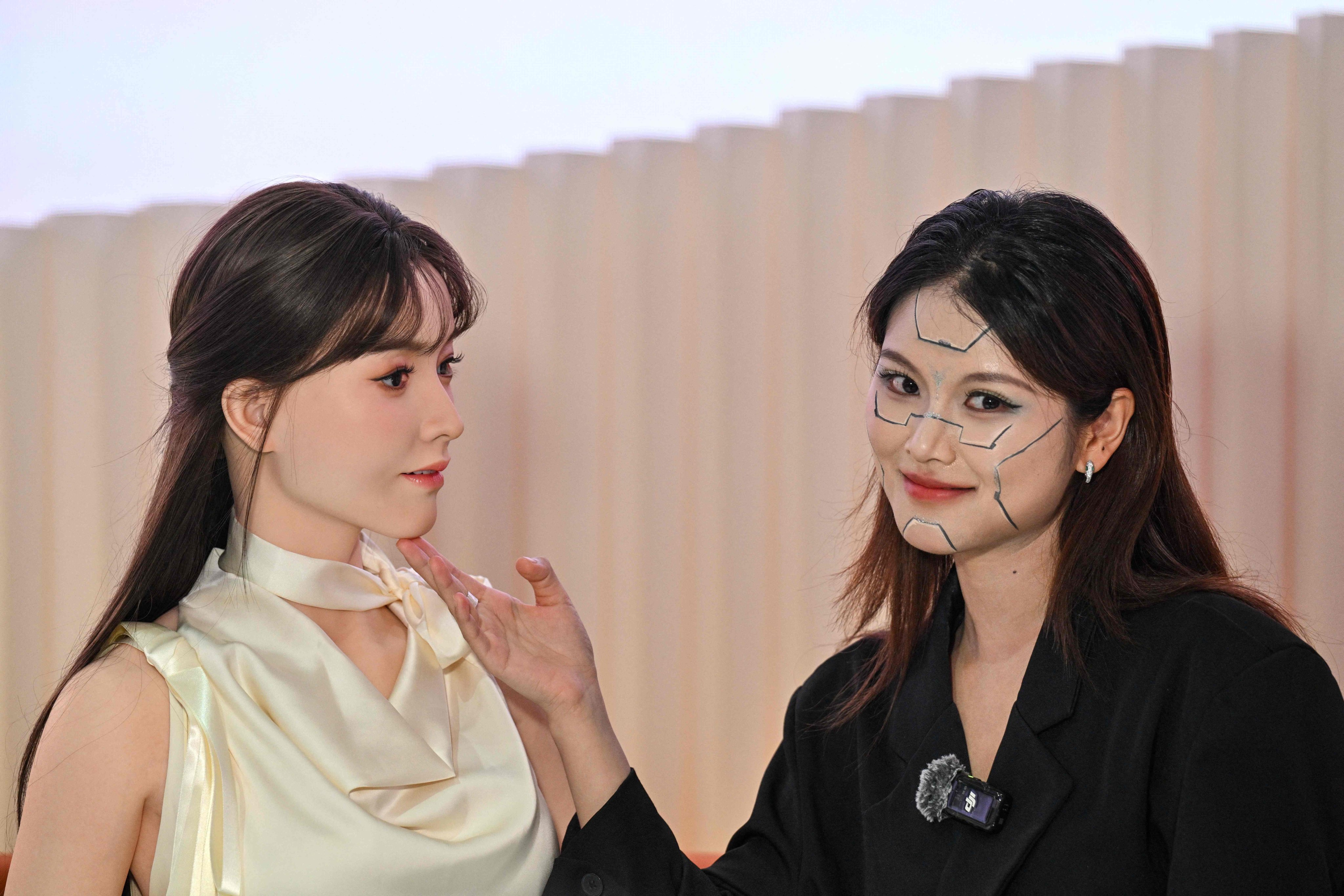 A woman, right, interacts with a humanoid robot at the launch event of UBTech’s U1 series. Photo: AFP