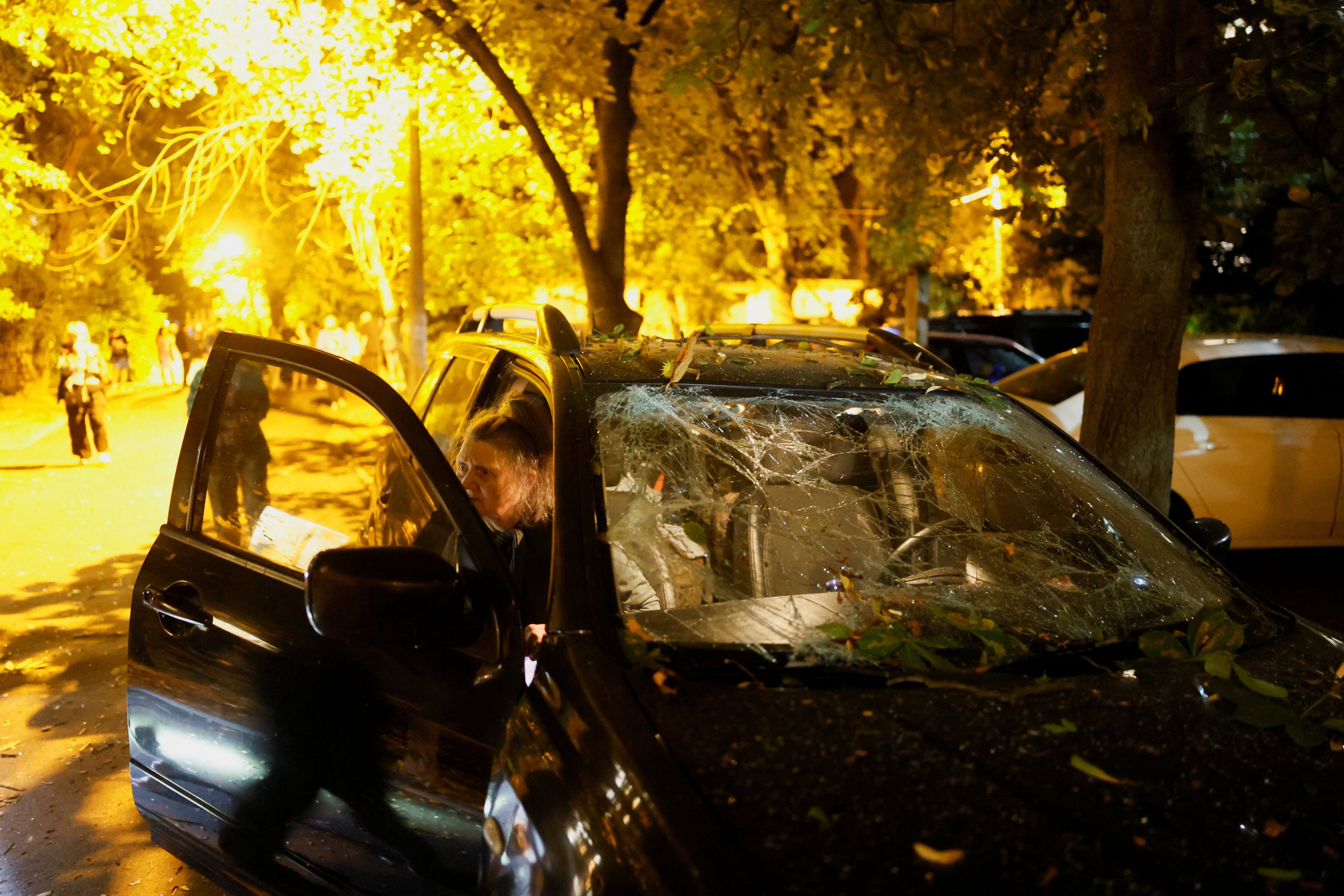 A driver gets out of a damaged vehicle near a residential building hit by a Russian missile strike on Saturday. Photo: Reuters