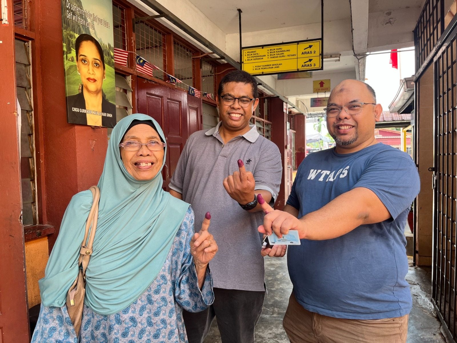 Voters in Ampangan, Seremban, show proof they have cast their ballot on Saturday. Photo: Ushar Daniele