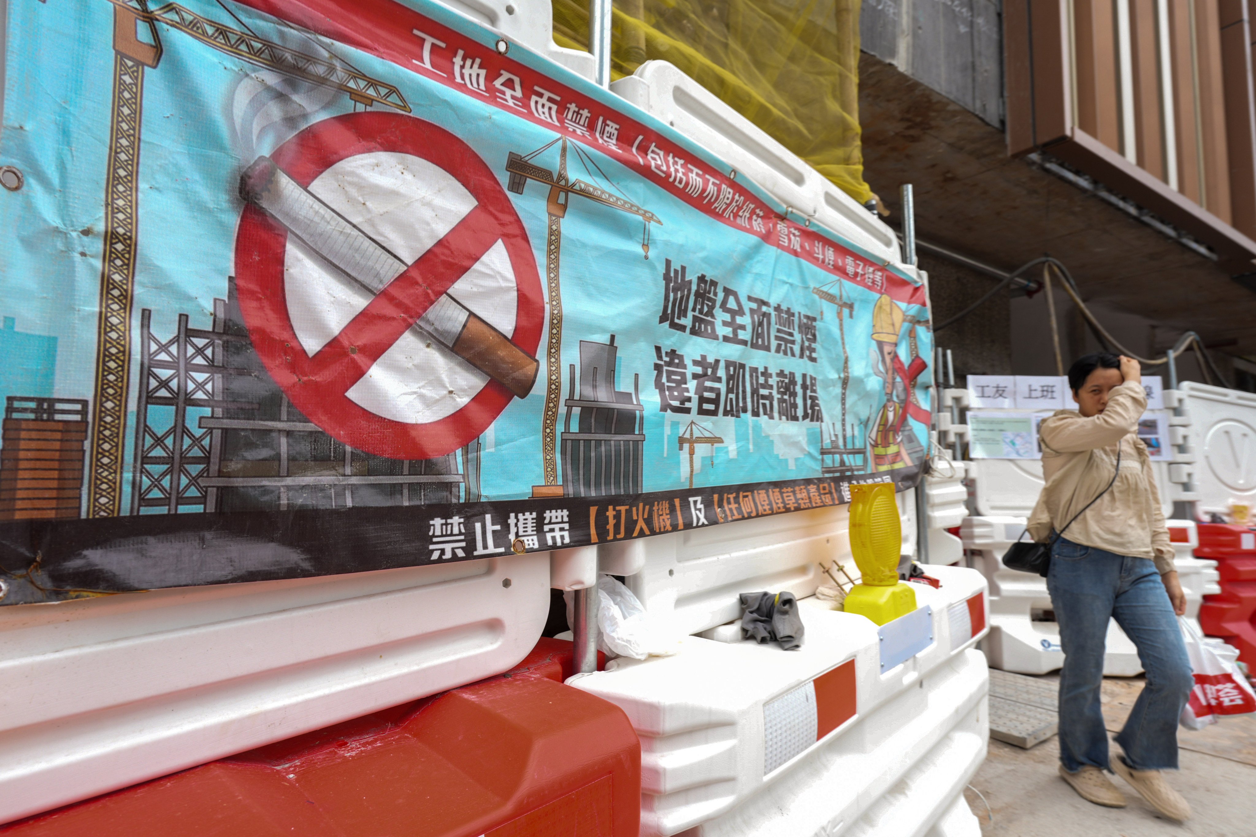 A banner about the smoking ban  is displayed at a Fanling construction site. Under the legal amendments, anyone caught smoking at a construction site faces a fixed penalty of HK$3,000 (US$380) for individual breaches. Photo: Eugene Lee