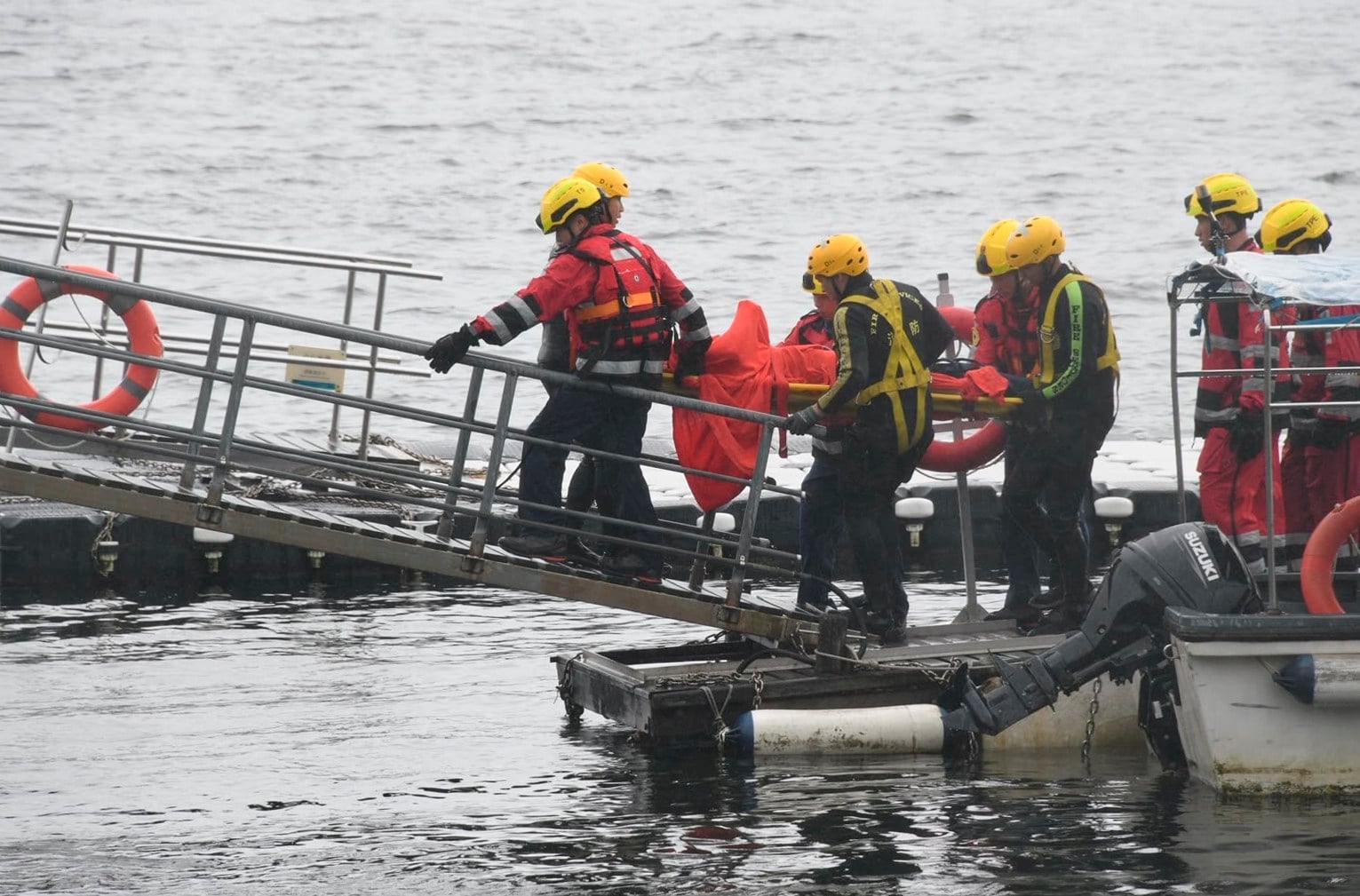 Fire Services Department rescuers transfer the body of the triathlete on a stretcher. Photo: Handout