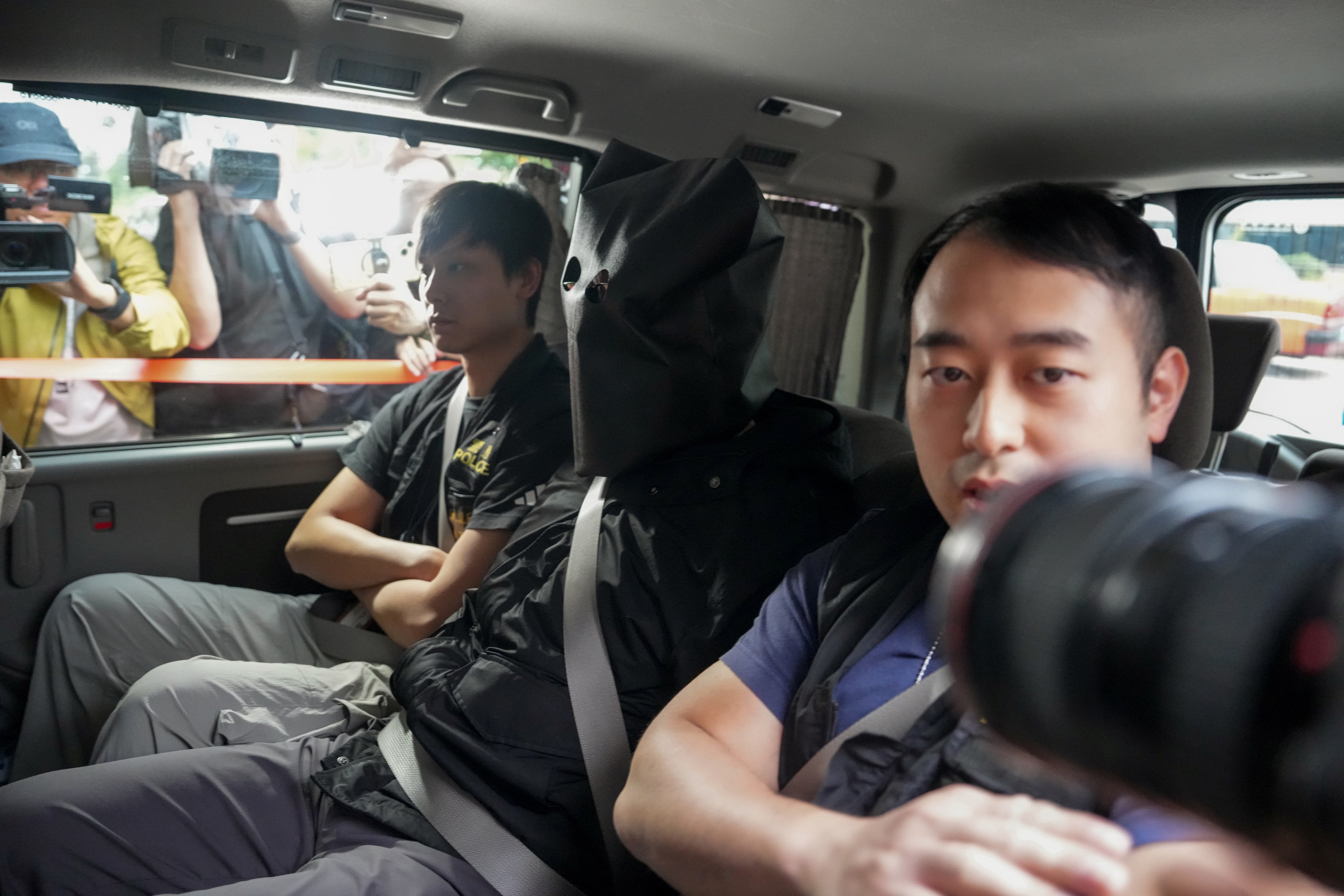 Police officers escort one of the suspects in the murder case. Photo: Sam Tsang