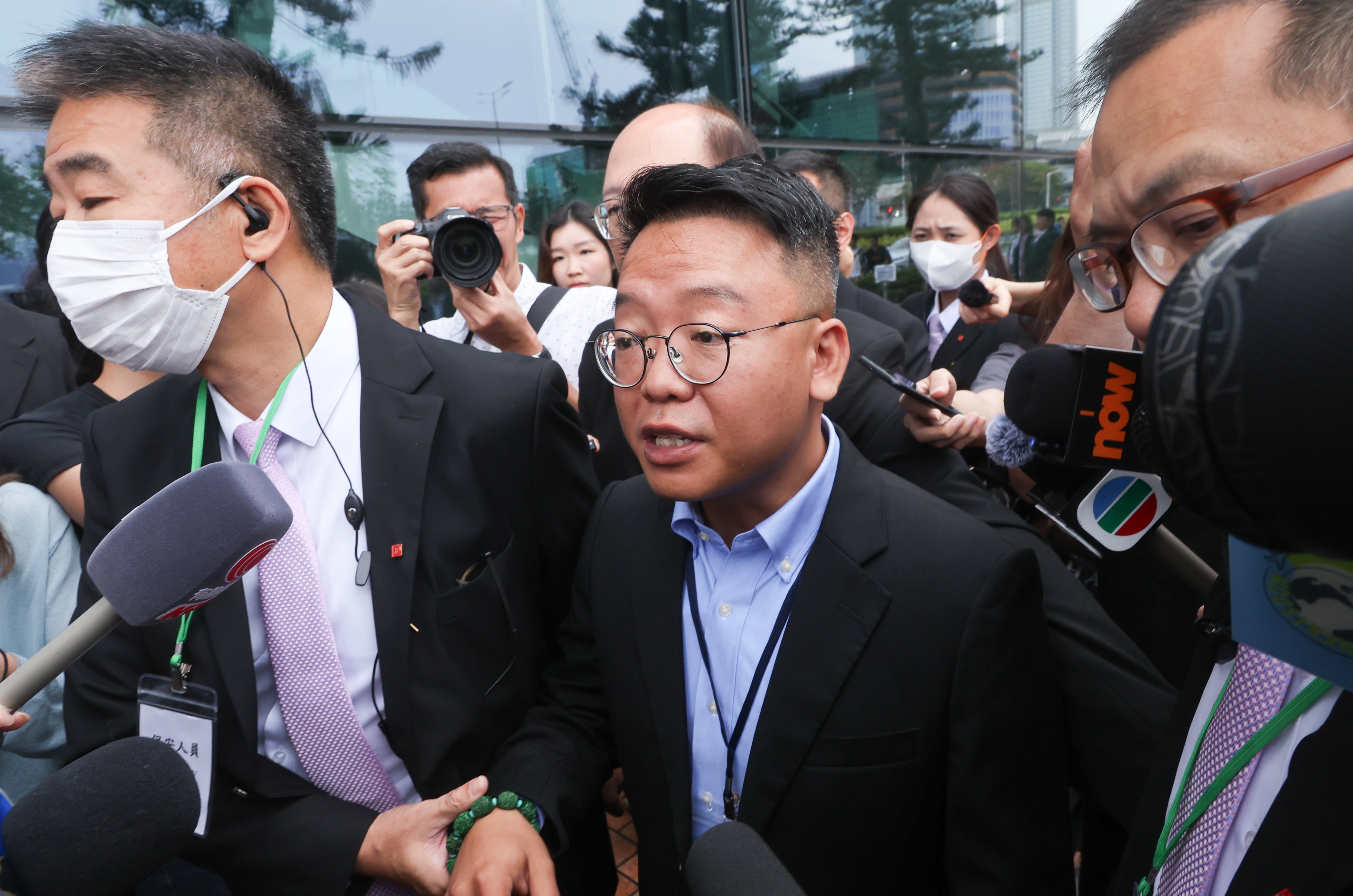 Chung Kit-man (centre), director of Victory Fire Engineering, leaves City Gallery in Central after appearing at the independent committee hearing on March 31. Photo: Edmond So