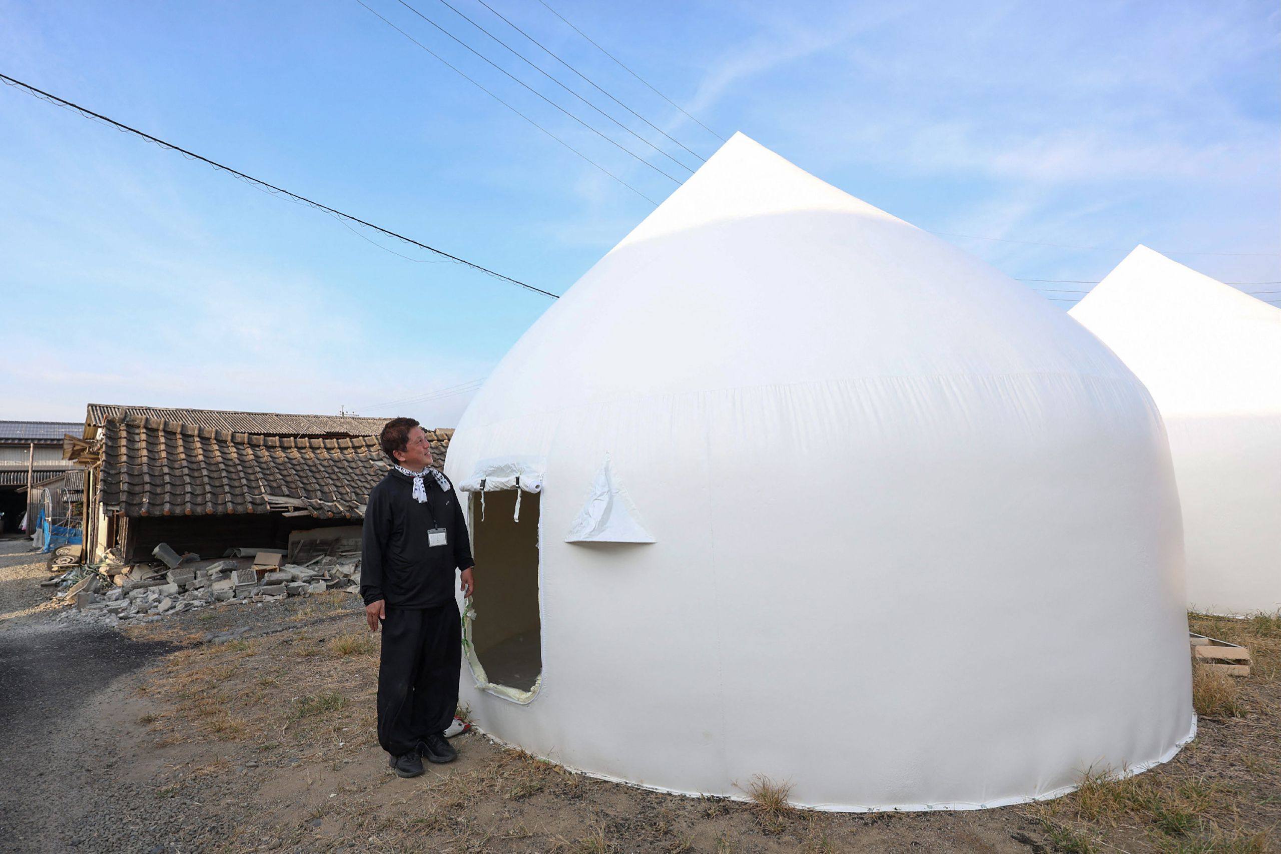 A man looks at a temporary shelter for people whose homes are damaged in as a damaged in Hikawa, Kumamoto prefecture on Saturday. Photo: Jiji Press/AFP