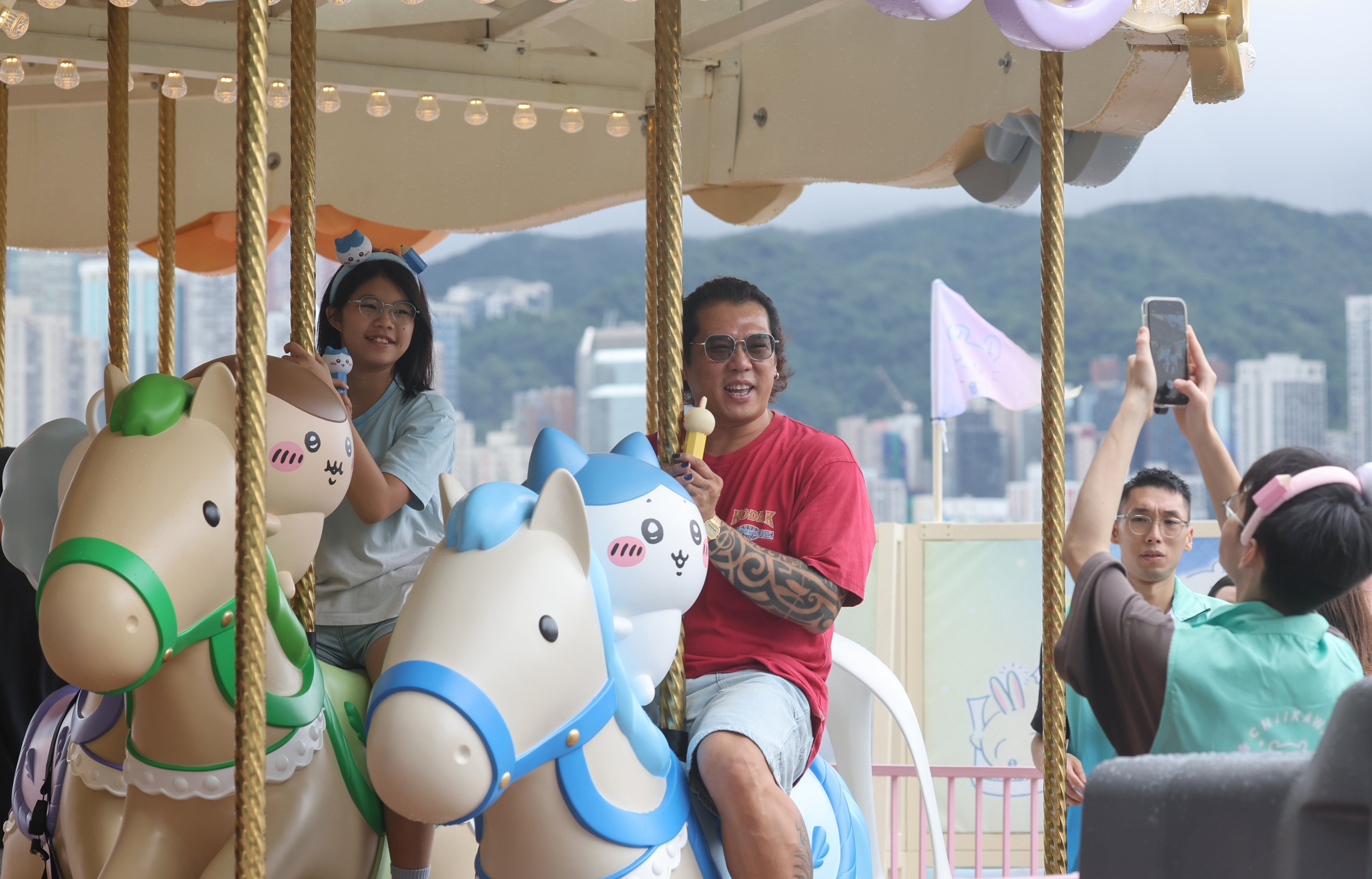 Visitors take pictures of themselves seated on the stationary merry-go-round in Tsim Sha Tsui. Photo: Edmond So