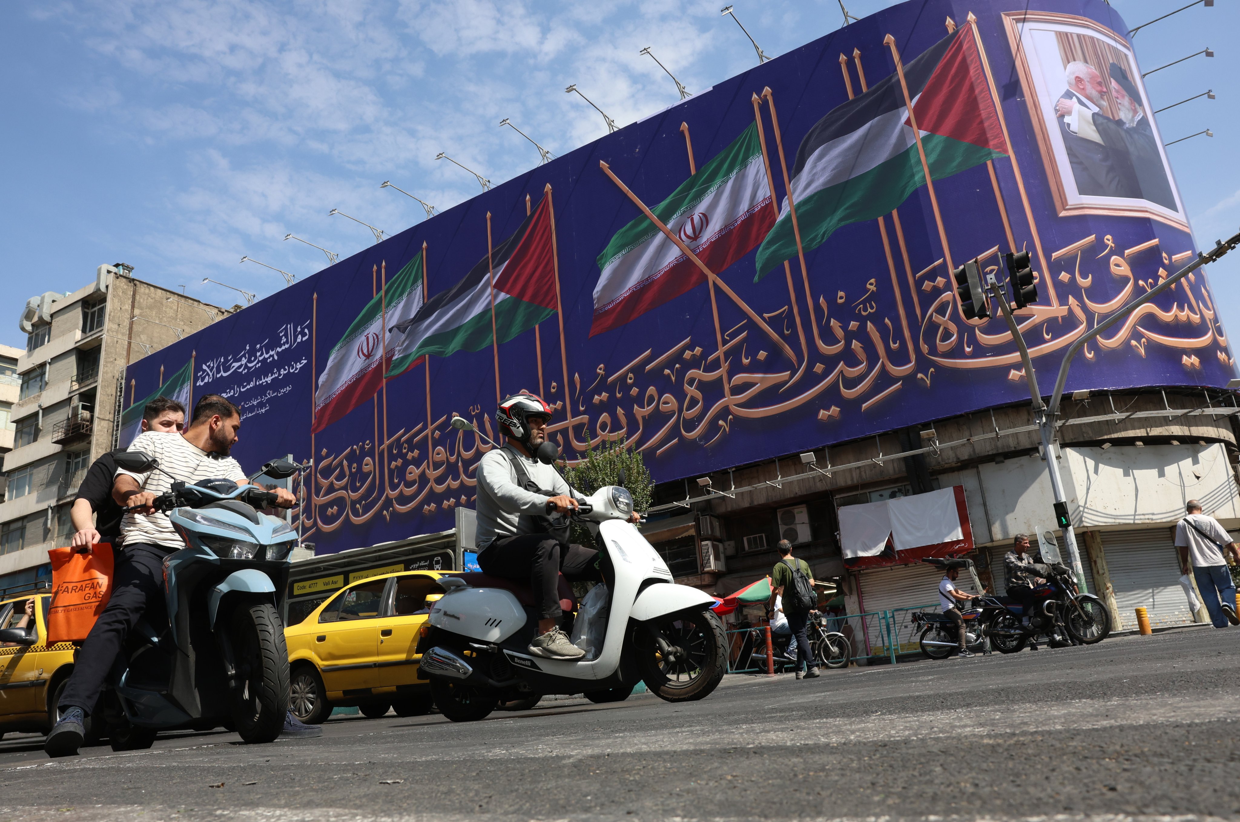 Iranian motorists drive past a hoarding displaying a portrait of Iran’s late Supreme Leader Ayatollah Ali Khamenei and late Hamas leader Ismail Haniyeh in Tehran on Saturday. Photo: EPA