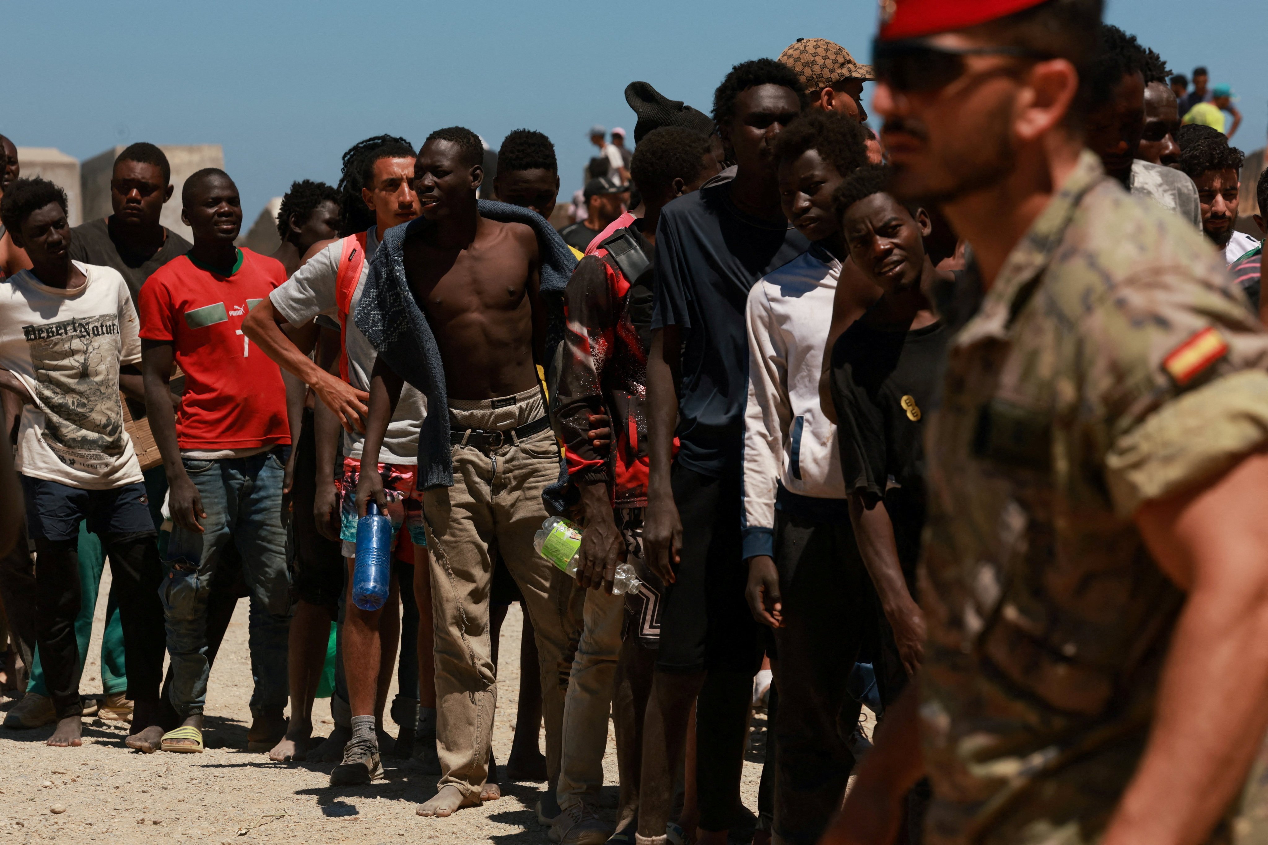 Migrants who crossed into Ceuta from Morocco queue for water provided by the Spanish military on Sunday. Photo: Reuters