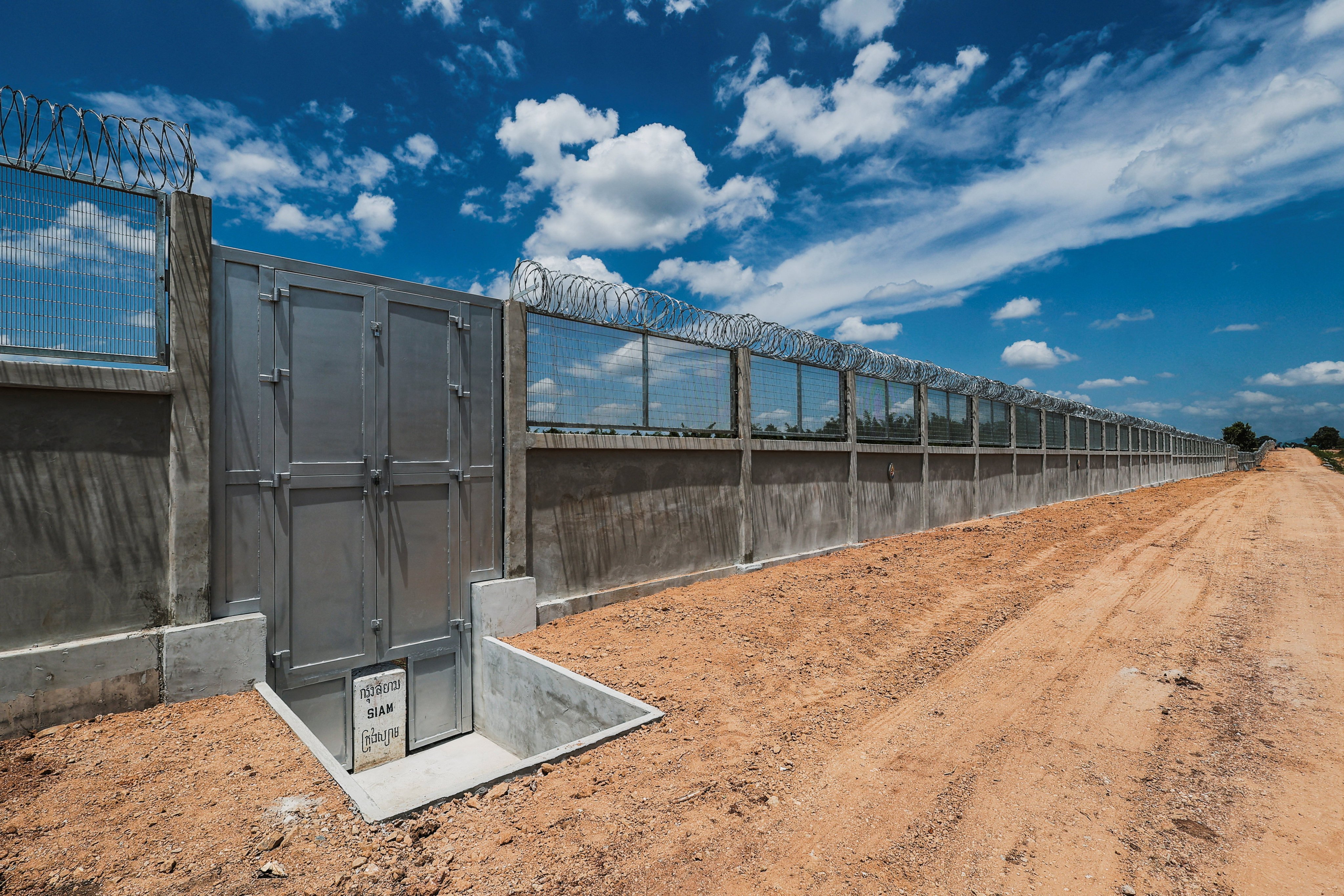 A concrete sign bearing the word “SIAM” is displayed at the base of a gate along a section of the border fence between Thailand and Cambodia in Pong Nam Ron district, Chanthaburi province, in Thailand on July. Photo: Reuters