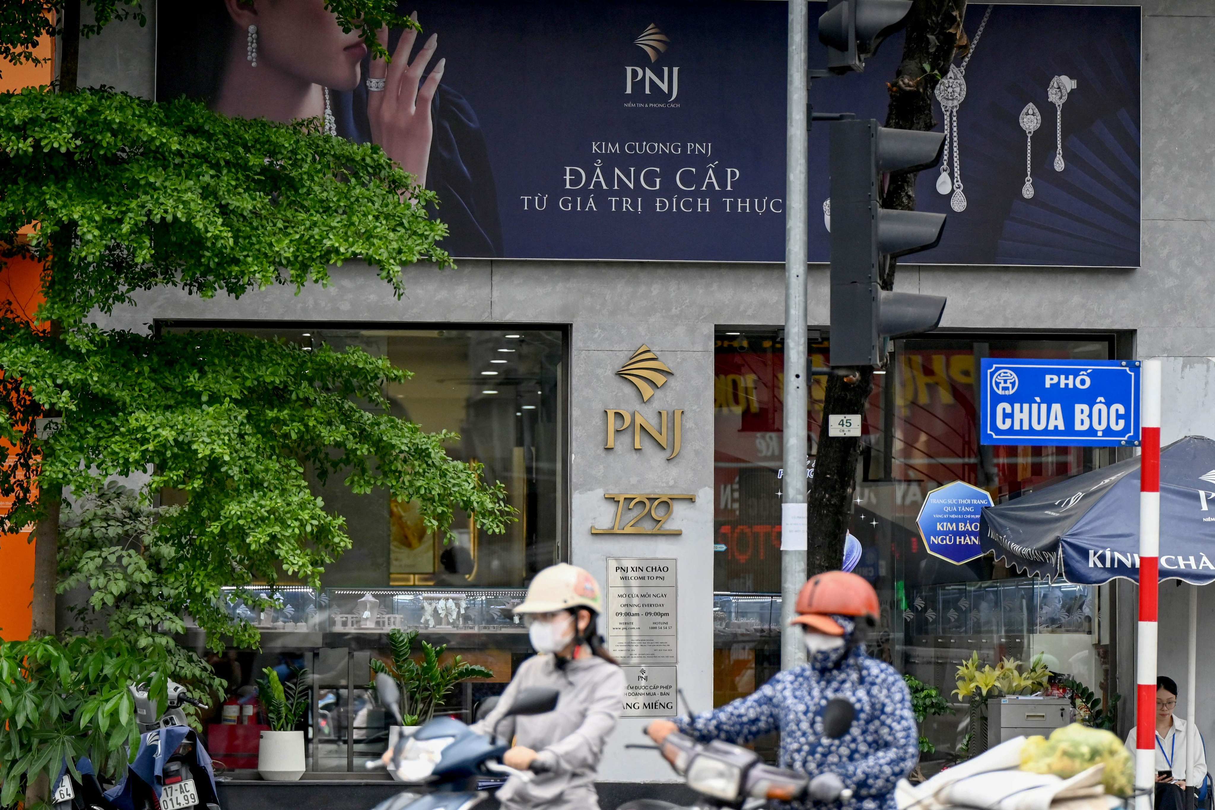 People ride past a Phu Nhuan Jewellery store in Hanoi on July 15, 2026. Photo: AFP