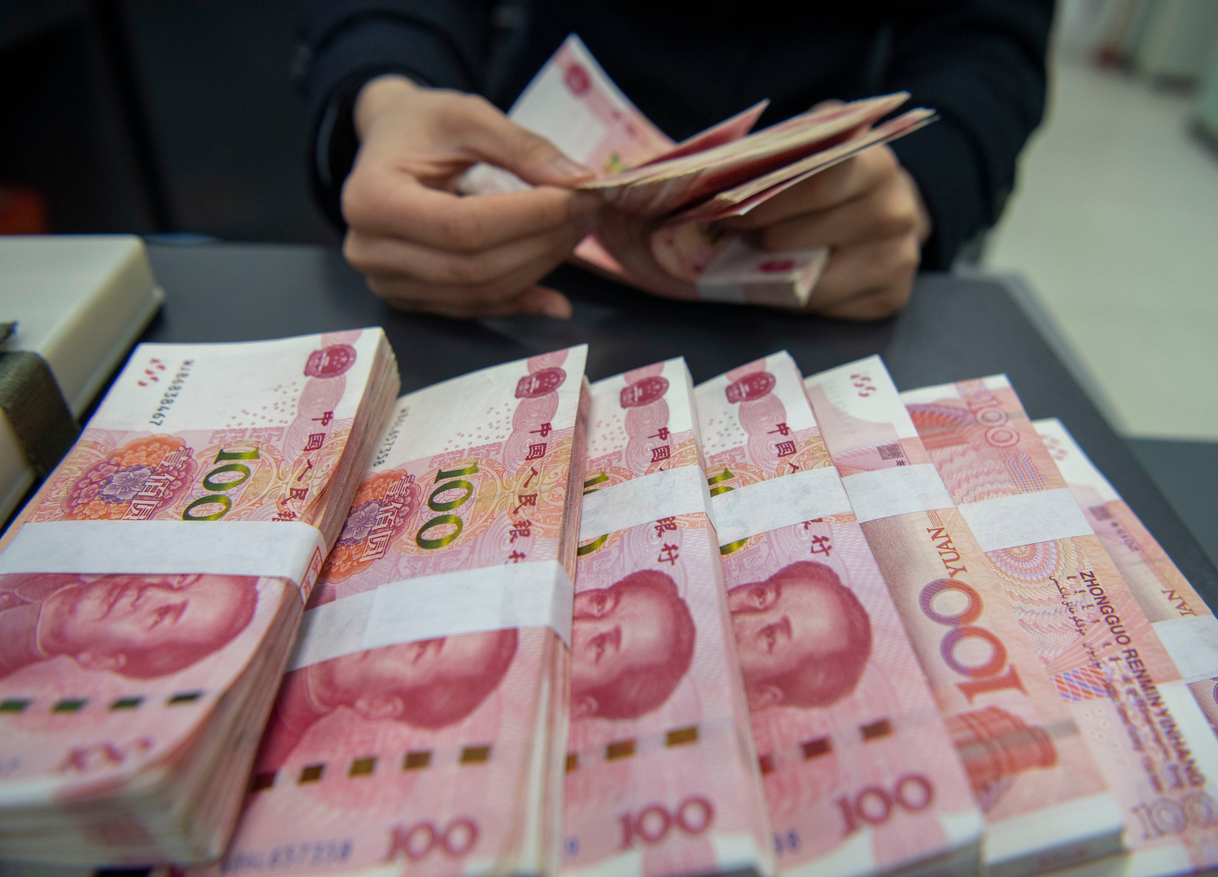 A staff member of a bank in Haian, Jiangsu province, counts 100 yuan notes in March 2024. Foreign institutions held around 2 trillion yuan of Chinese government bonds as of the end of June 2026. Photo: Getty Images