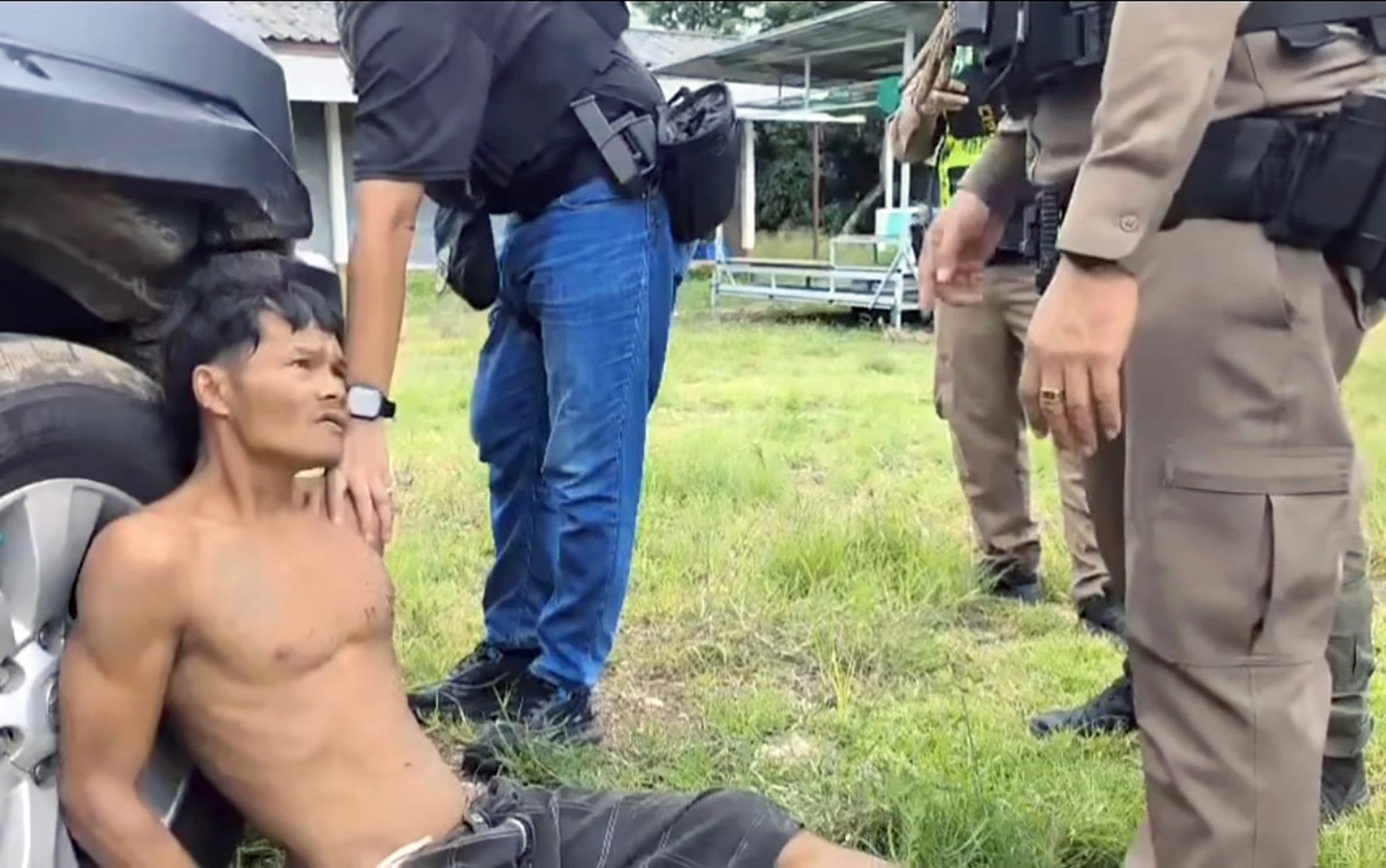 Thongchai Srinil sits handcuffed after being arrested by Thai police officers on Friday. Photo: Royal Thai Police/EPA