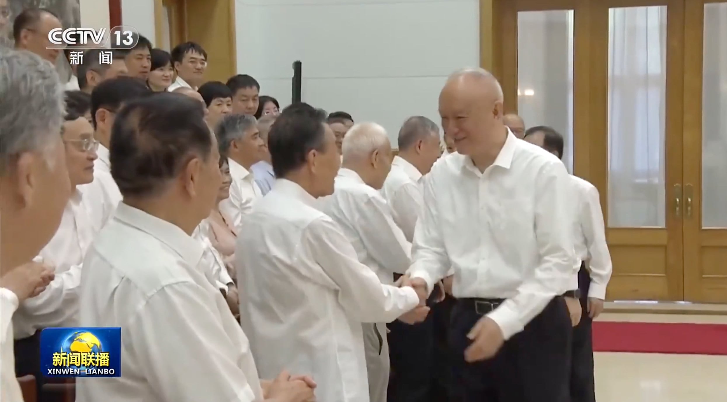 Cai Qi greets researchers and academics at Beidaihe. Photo: CCTV