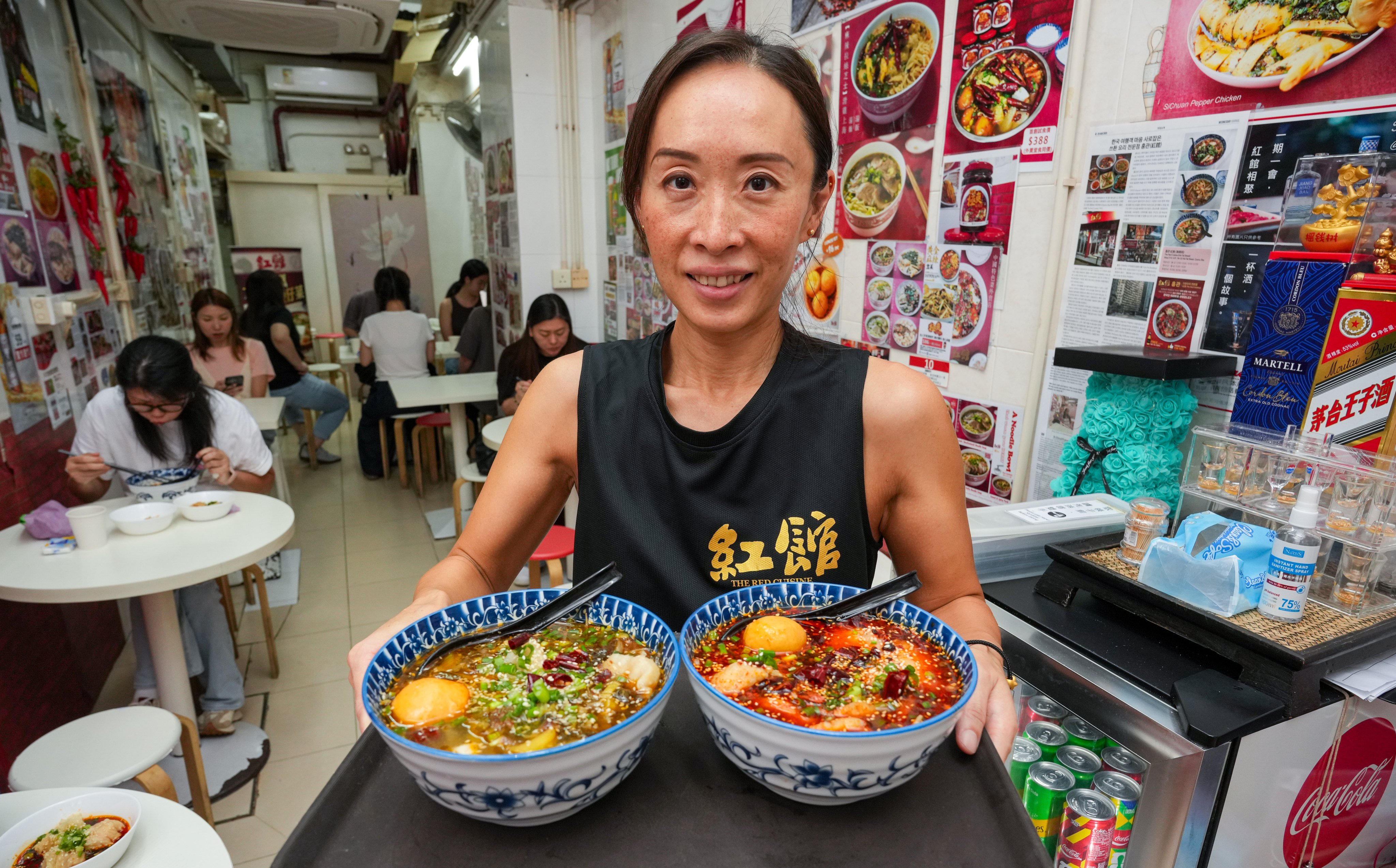 The Red Cuisine owner Joyce Yuen serves dishes at her restaurant in Quarry Bay, Hong Kong. Many restaurants in the city are struggling with falling customer numbers as more locals head to Shenzhen for cheaper meals. Photo: May Tse