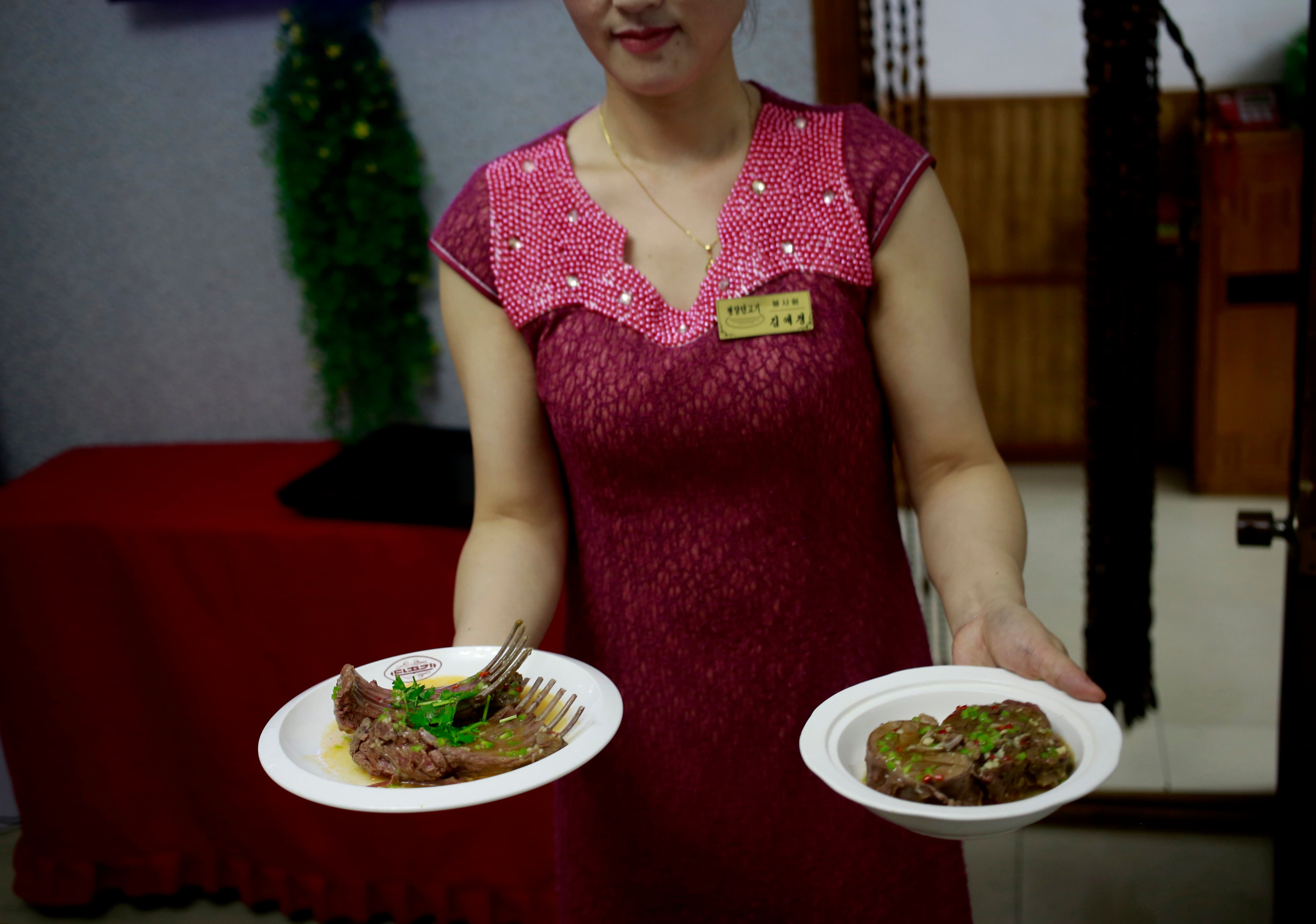 A waitress shows dishes made of dog meat at a restaurant in North Korea in 2018. Euphemistically known as “dangogi”, or sweet meat, dog has long been believed to be a stamina food in North and South Korea and is traditionally eaten during the hottest time of the year. Photo: AP