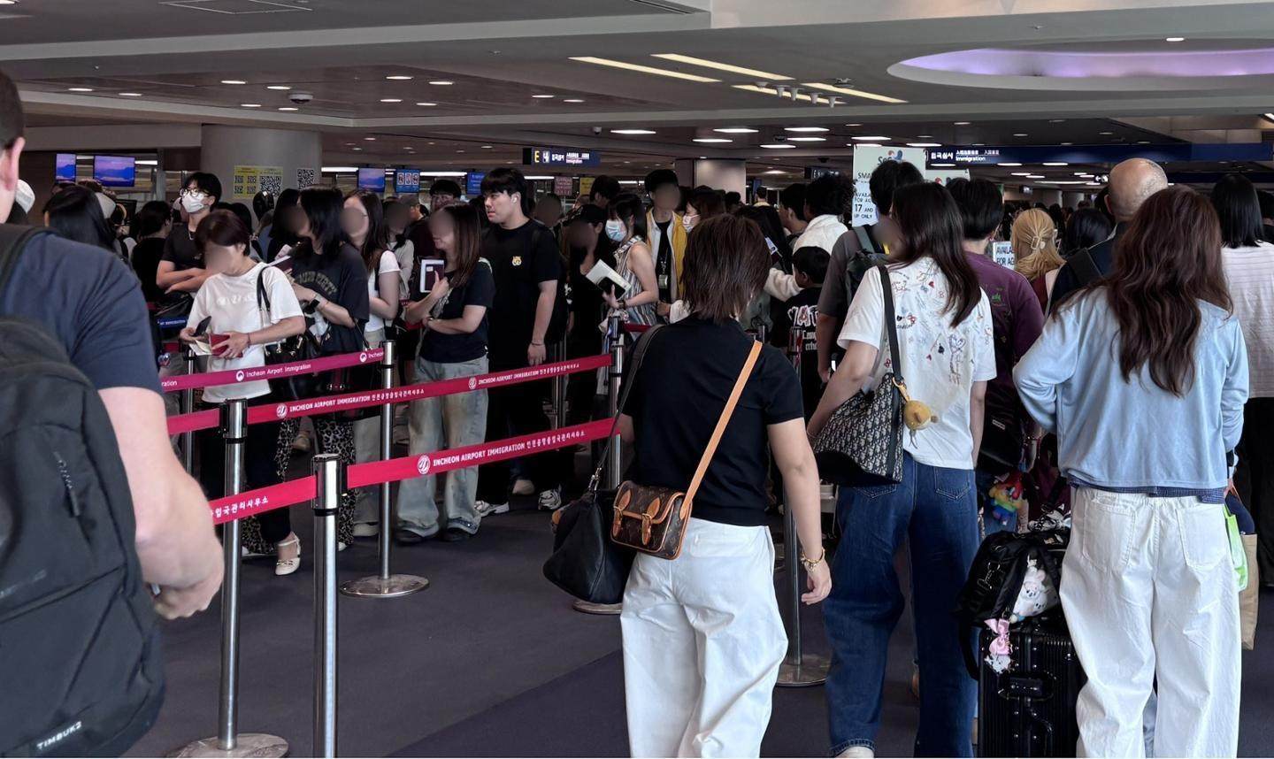 Foreign passengers wait in line to clear immigration at the arrivals hall of Incheon International Airport’s Terminal 1 on Friday. Photo: The Korea Times