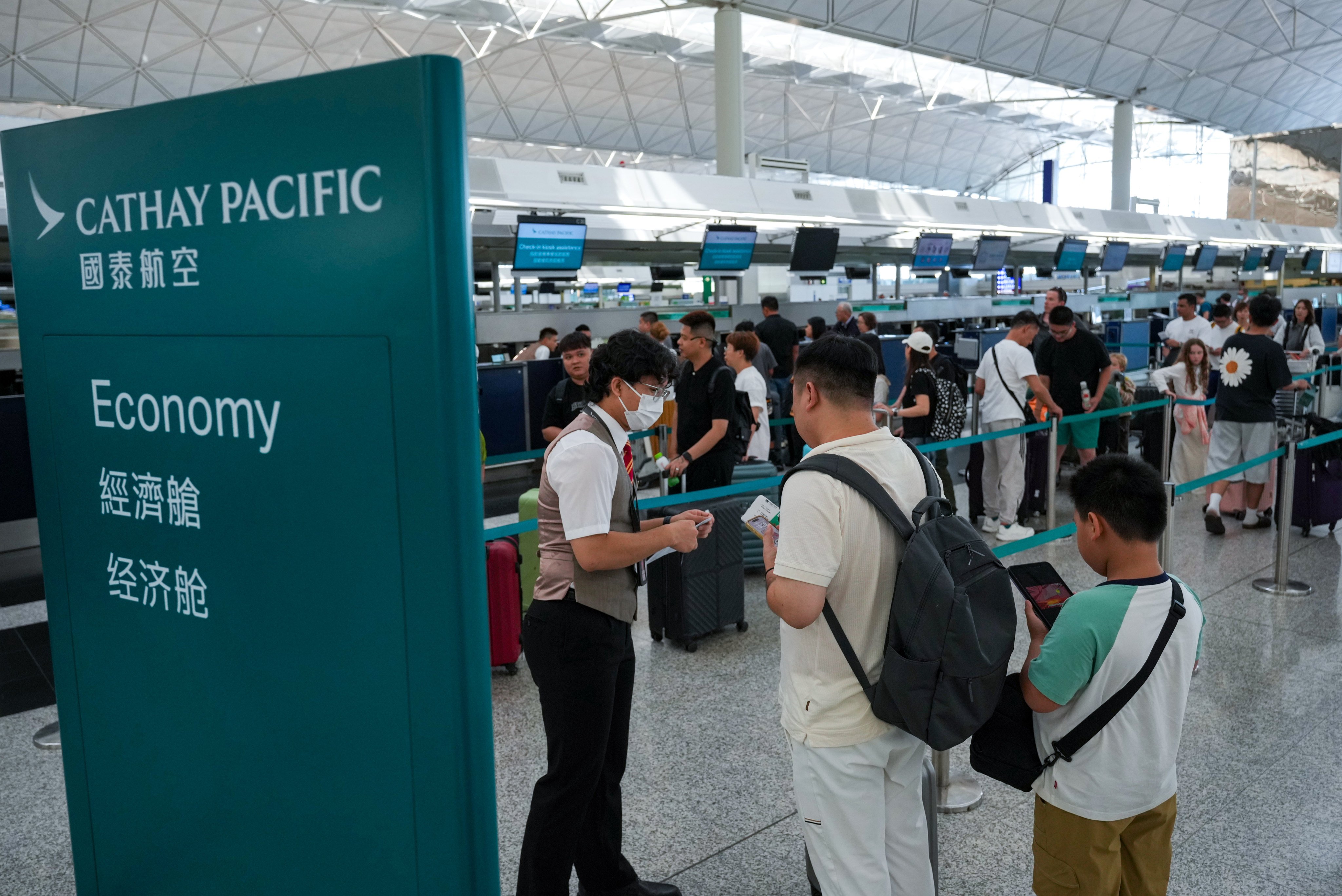 Customers check in for their flights at the Cathay Pacific counters at Hong Kong International Airport. Photo: May Tse