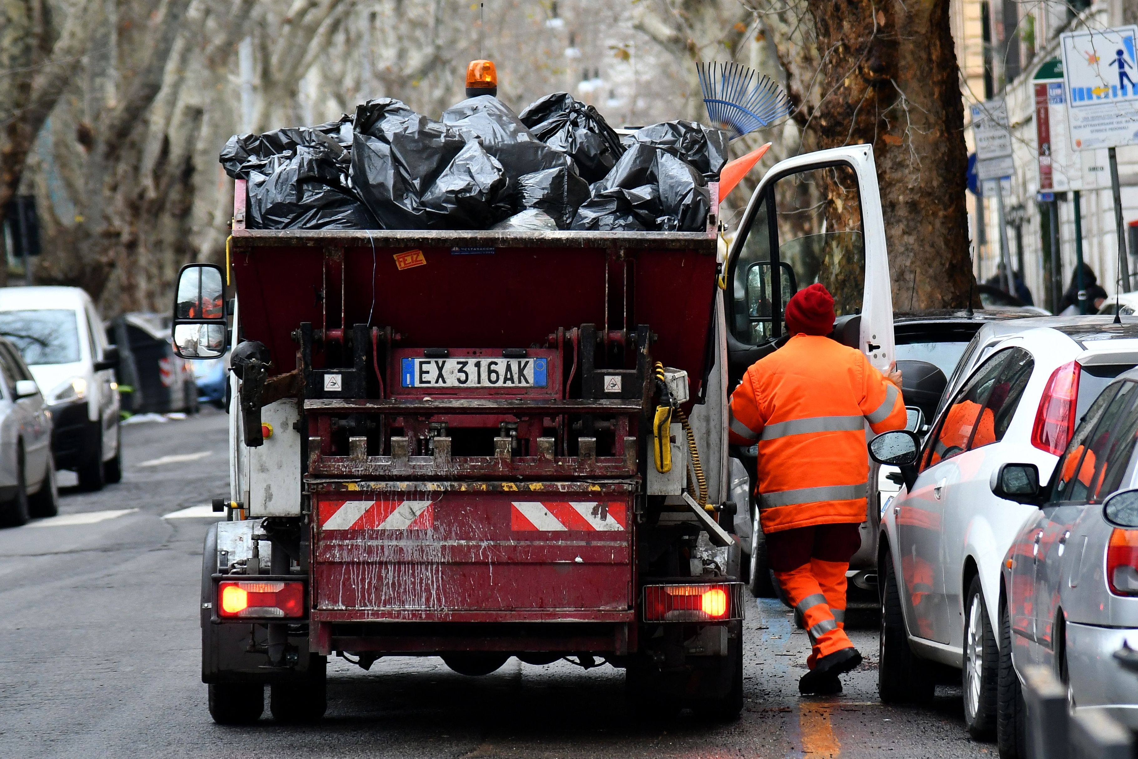 A rubbish collection worker gets in his truck in Rome in January 2018. Photo illustration: AFP