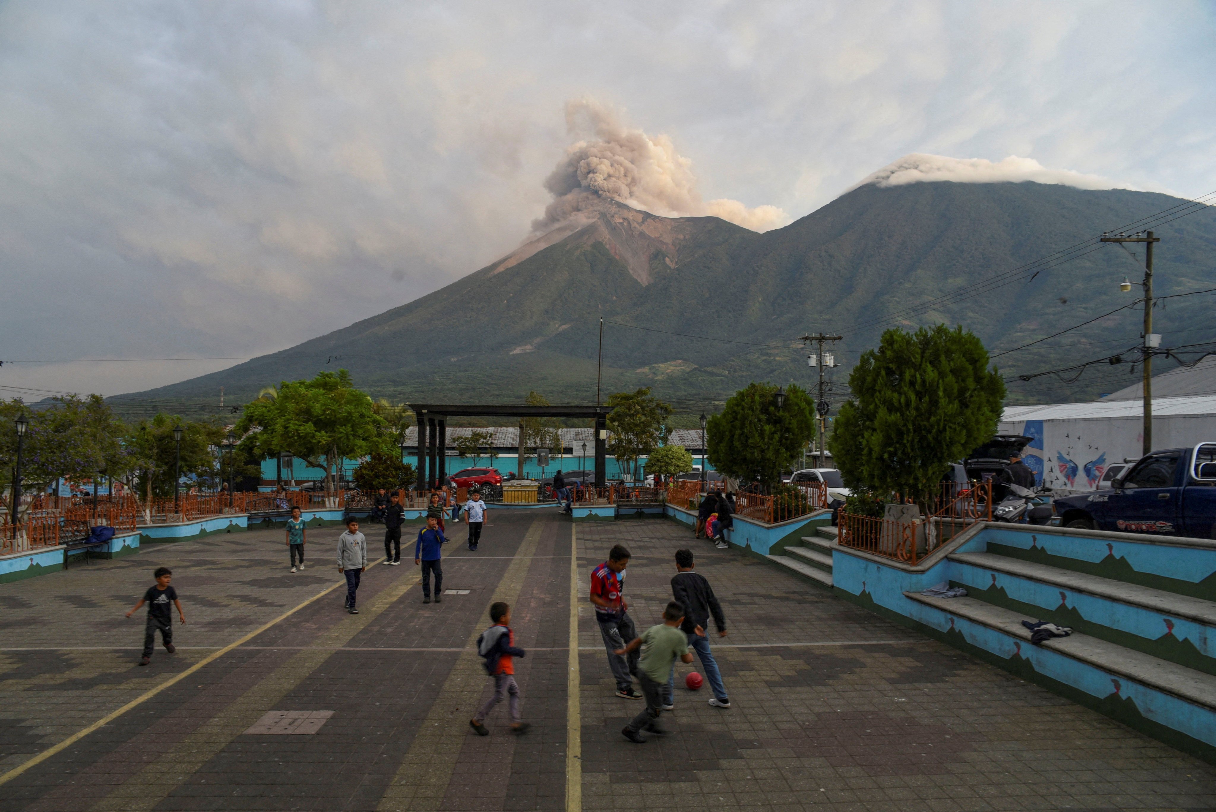 Children play as Guatemala’s Fuego volcano erupts. Photo: Reuters