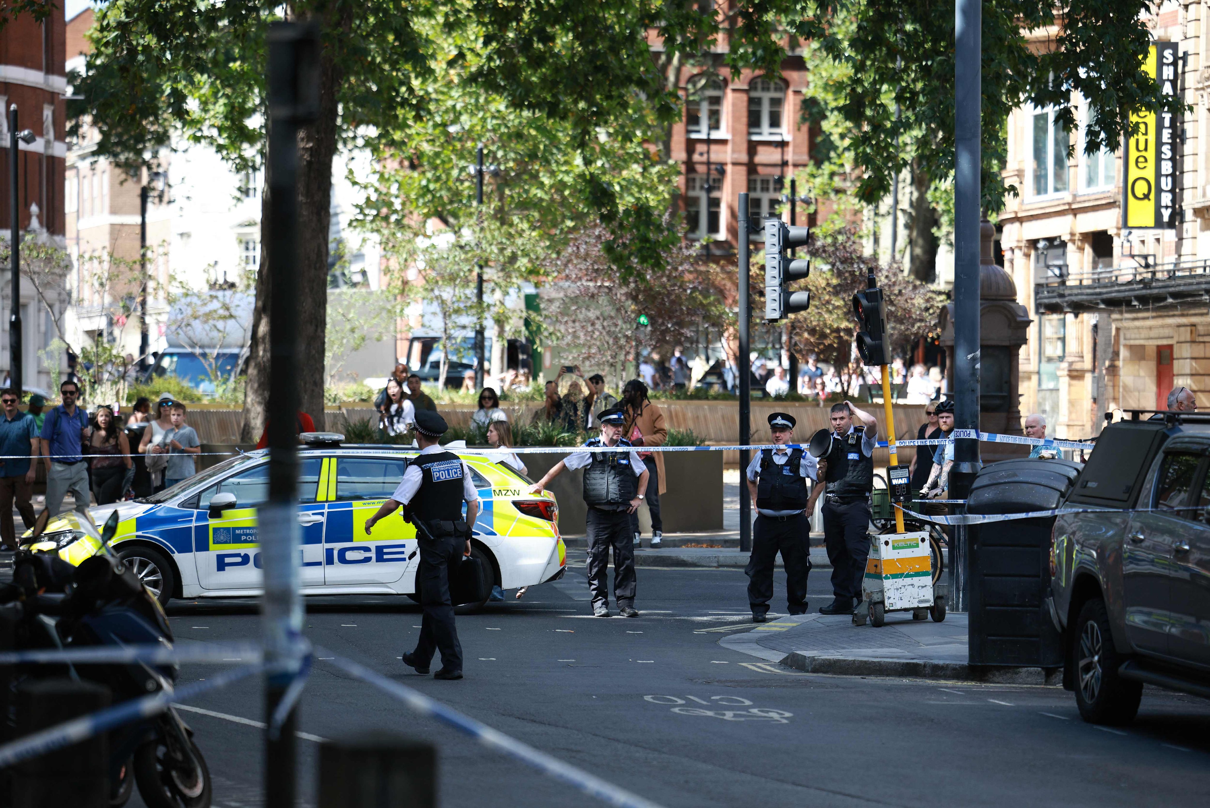 Police officers stand at a cordon near the Shaftesbury Theatre, central London, on Wednesday. A woman was arrested after four men were stabbed in Covent Garden. Photo: AFP