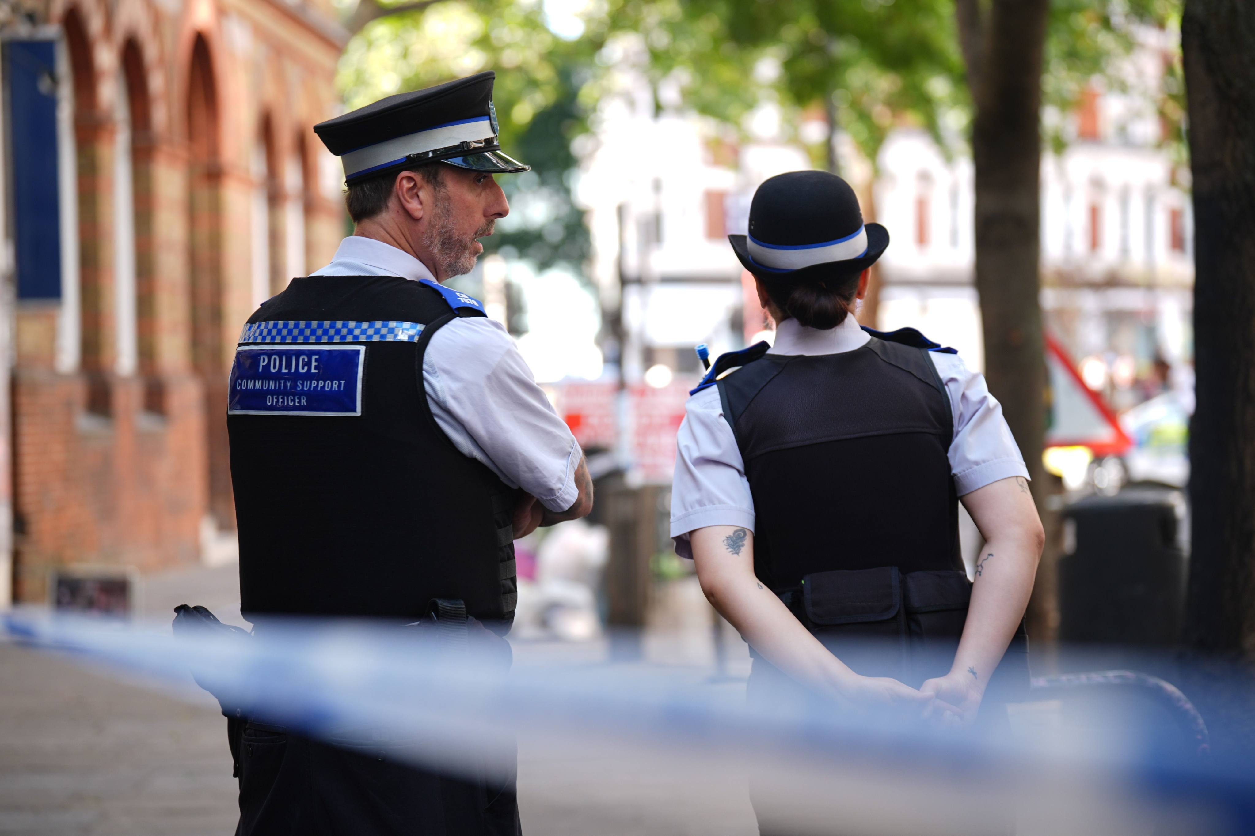 Police officers stand near the scene in Covent Garden where four men were stabbed on Wednesday. Photo: PA Wire/dpa