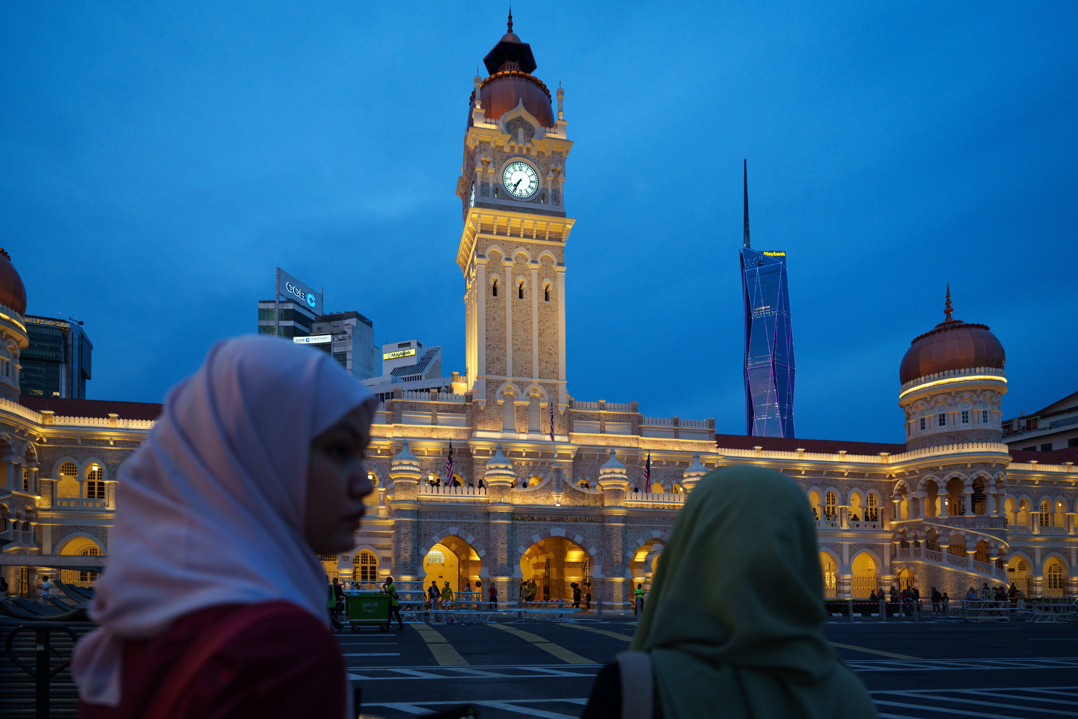 Women walk past the illuminated Sultan Abdul Samad Building in Kuala Lumpur, Malaysia, on July 26. In recent weeks, Prime Minister Anwar Ibrahim’s multi-ethnic governing coalition has suffered two consecutive defeats in state elections following campaigns dominated by racial and religious appeals. Photo: AP
